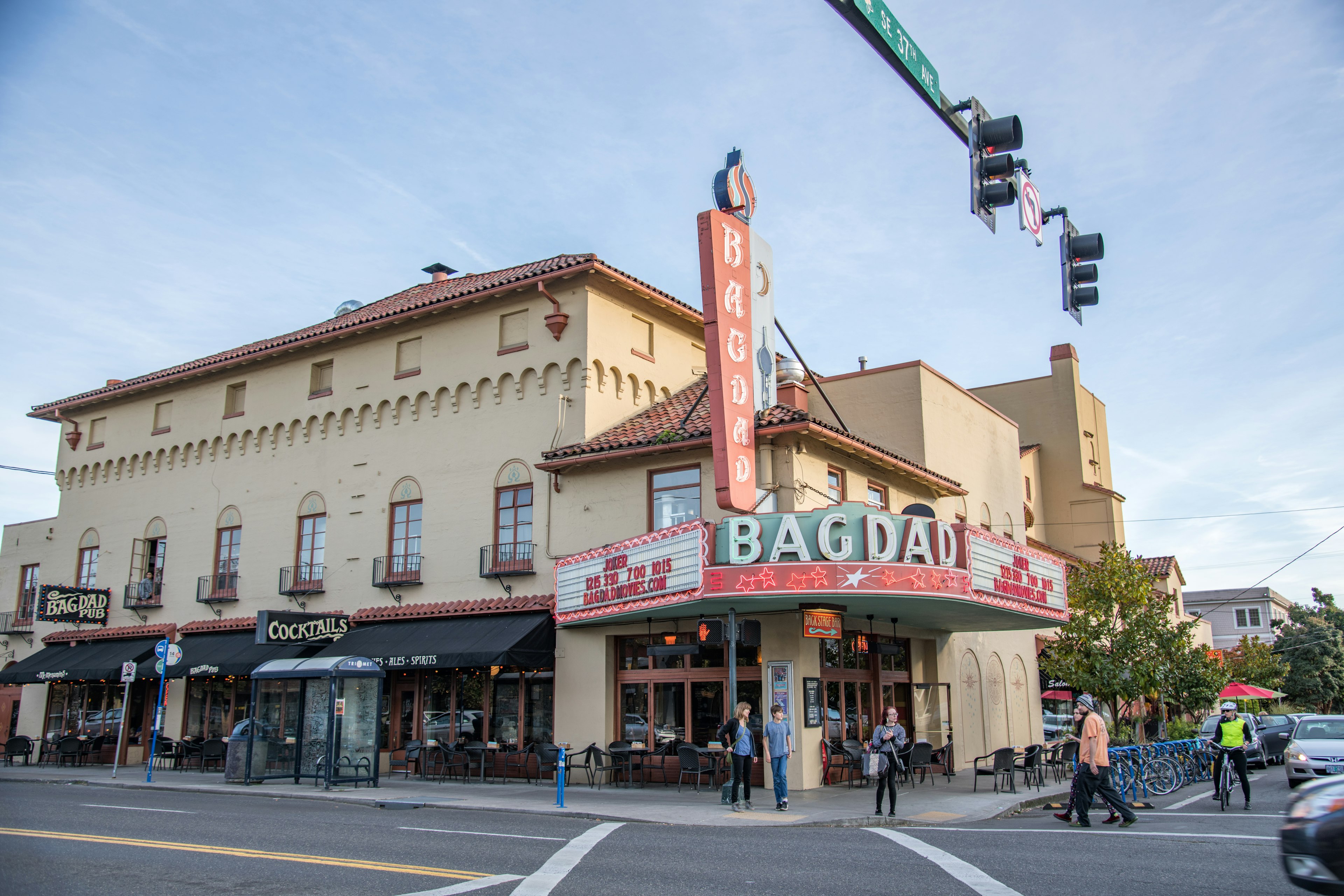 People walk on the street in front of the facade and marquee of the historic Bagdad Theater in the Hawthorne District of Portland, Oregon, USA