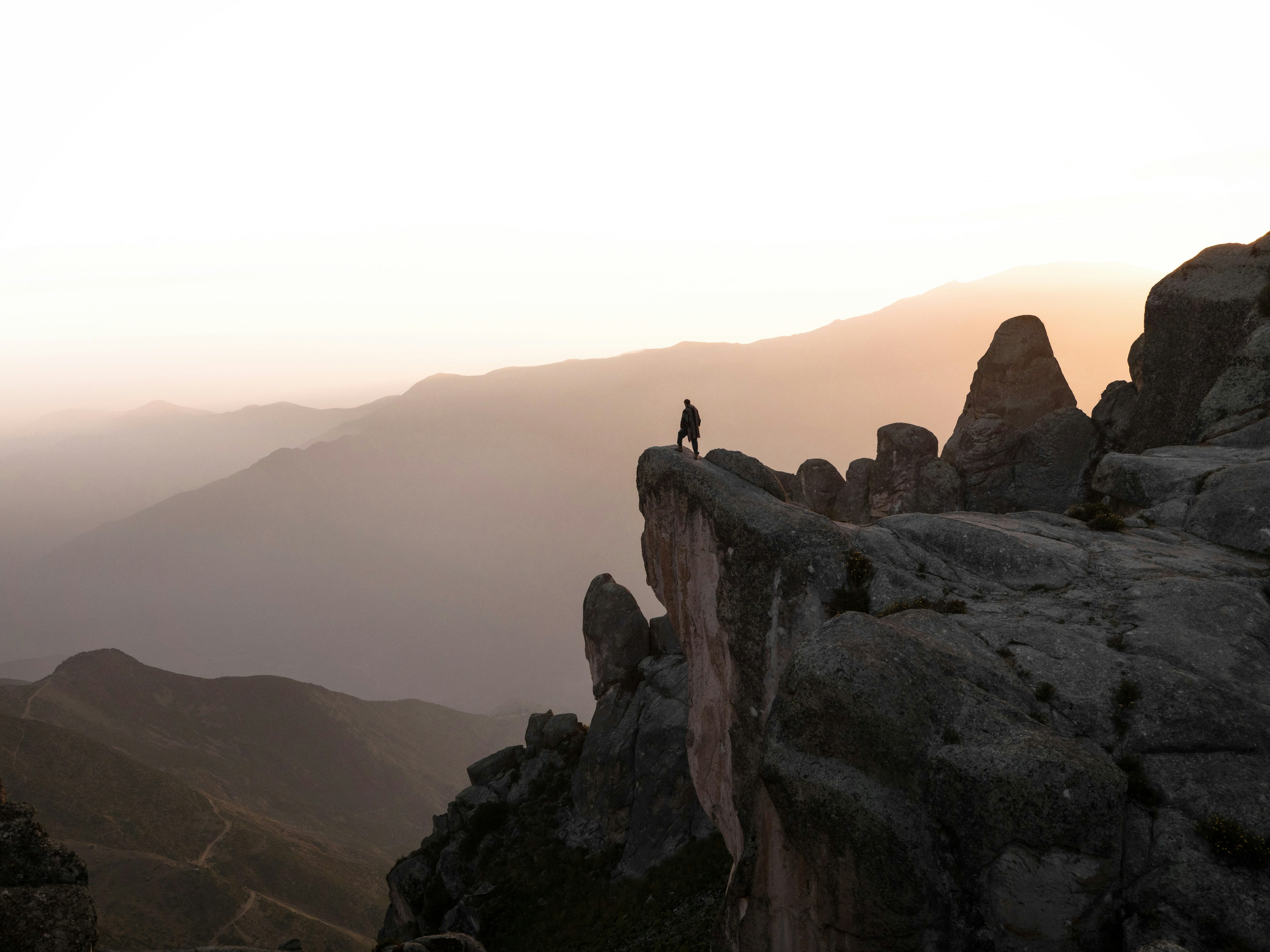 A solitary figure, in the dawn light, looks over a panoramic view from Marcahuasi, a plateau in the Andes Mountains
