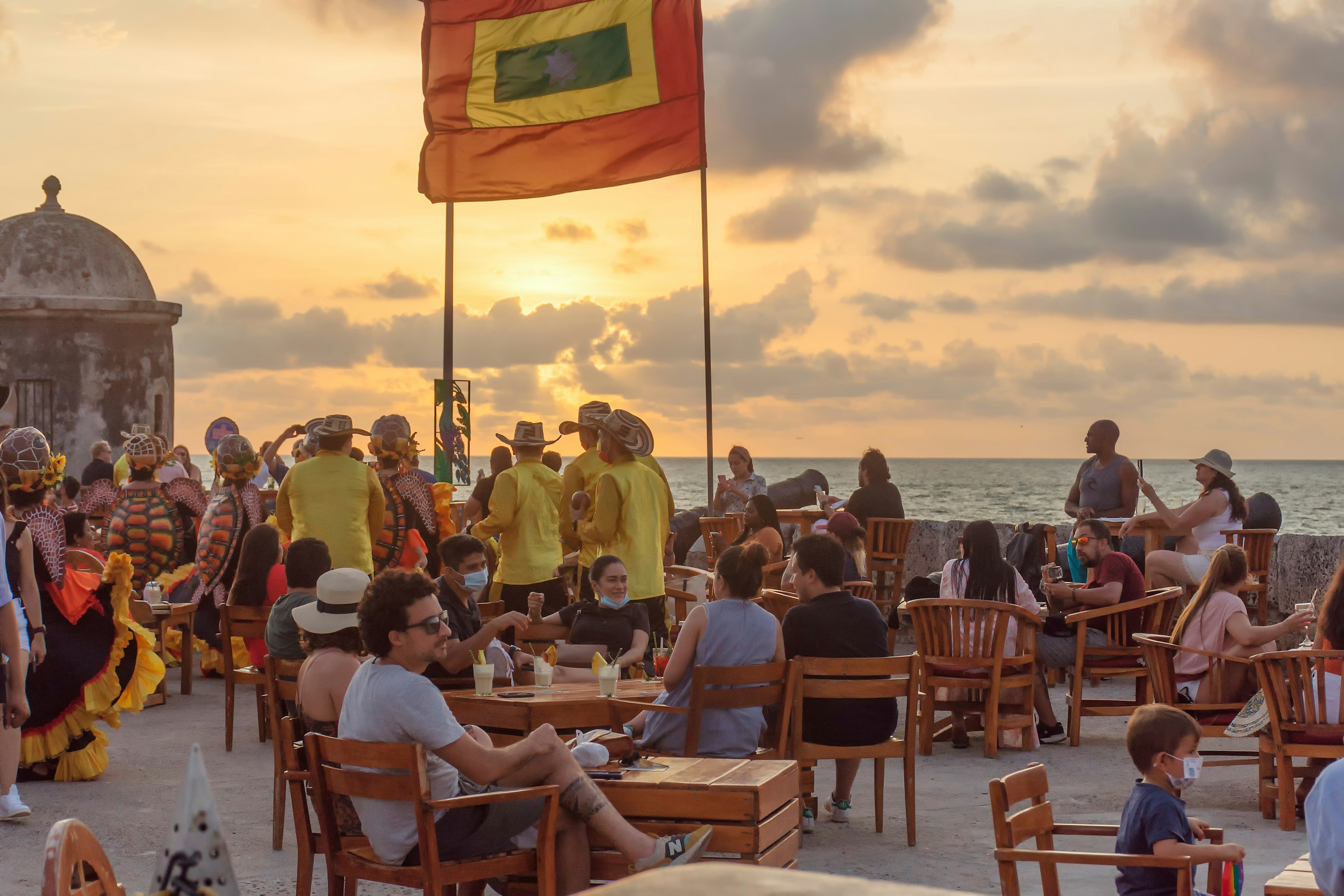 The dancers and musicians present the musical number of colombian caribbean to the tourists in the Cafe del Mar, on the wall of Cartagena at the sunset.