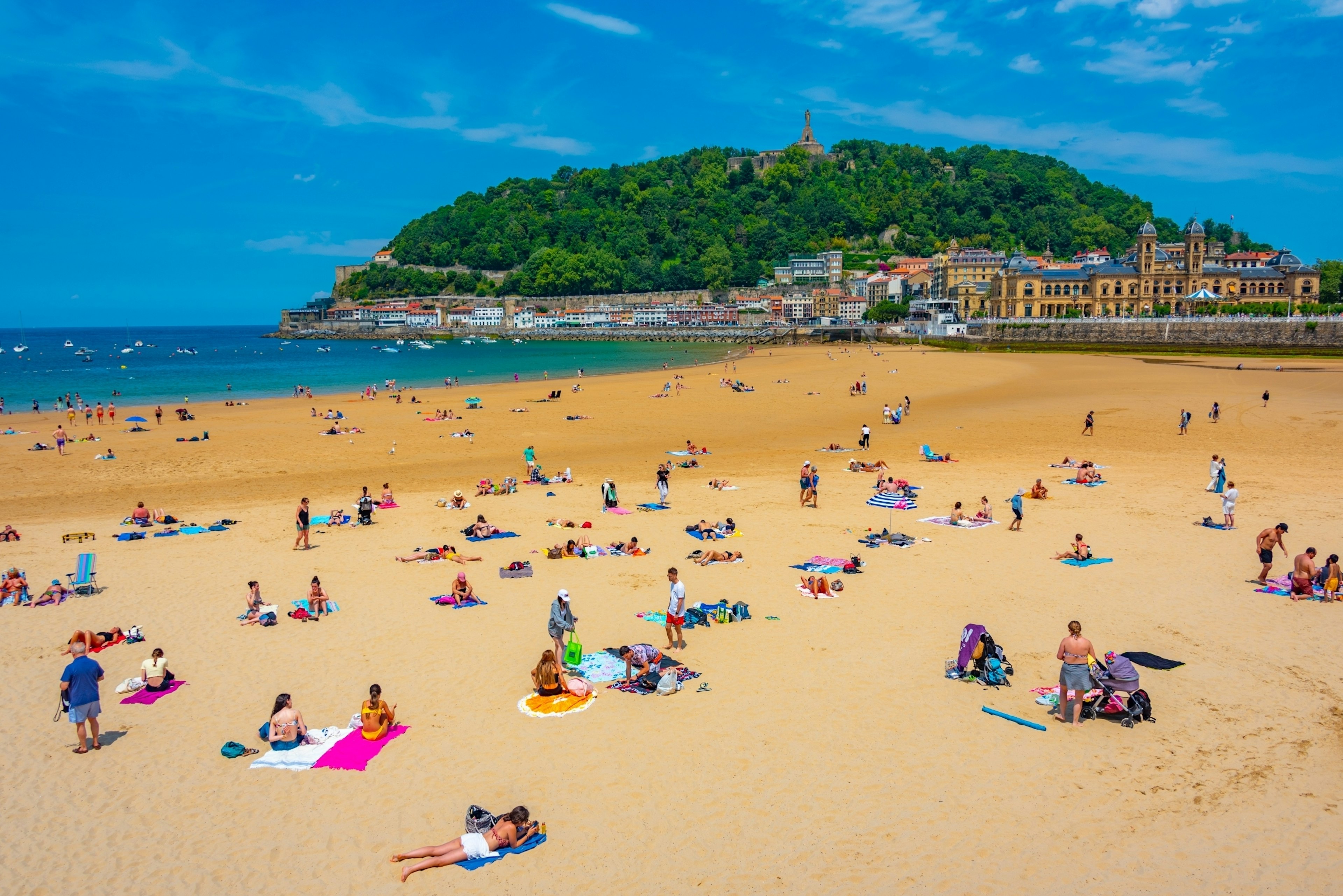 People enjoying a sunny day at La Concha beach at San Sebastian, Spain.