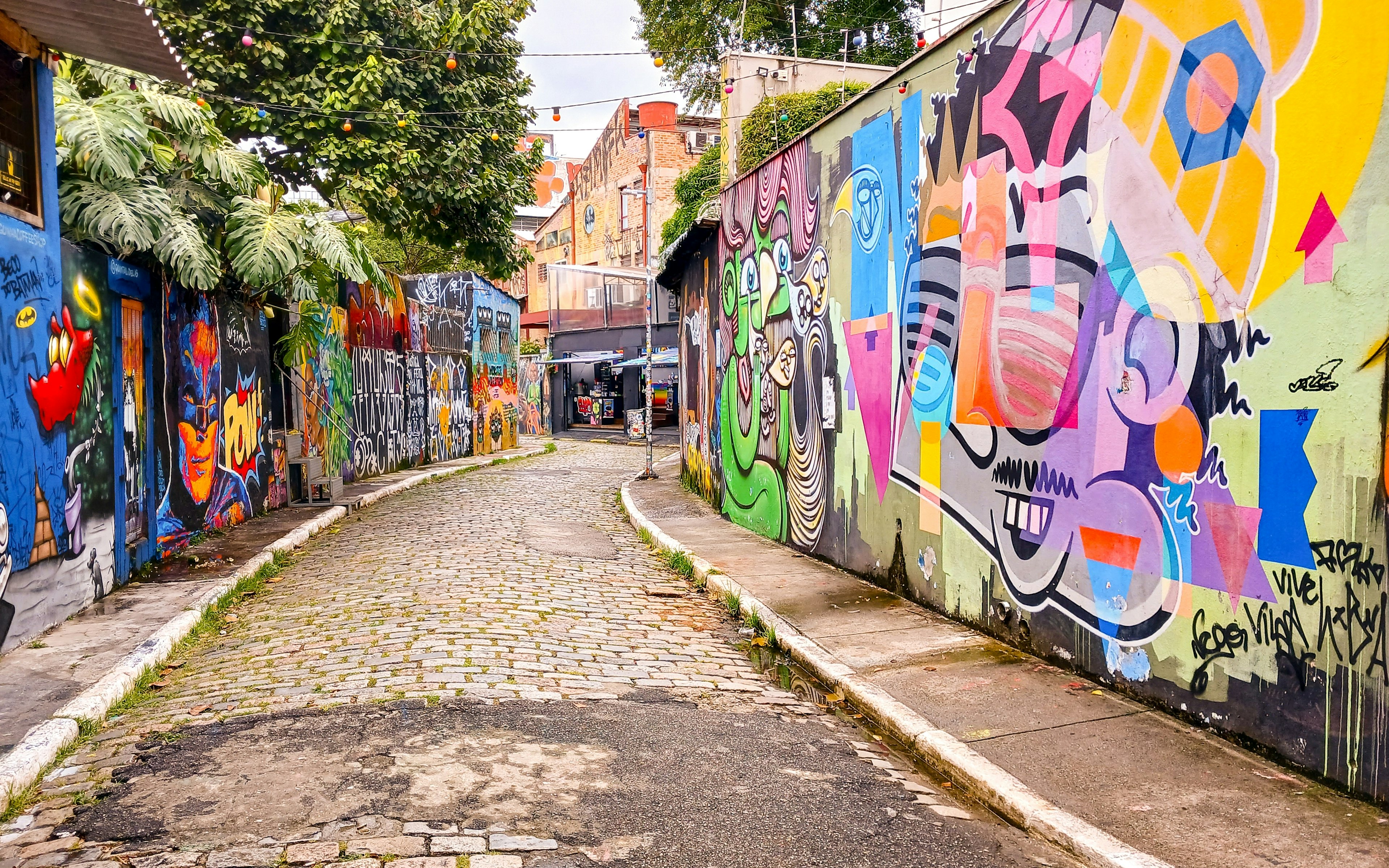 A cobbled street lined with colorful street-art designs