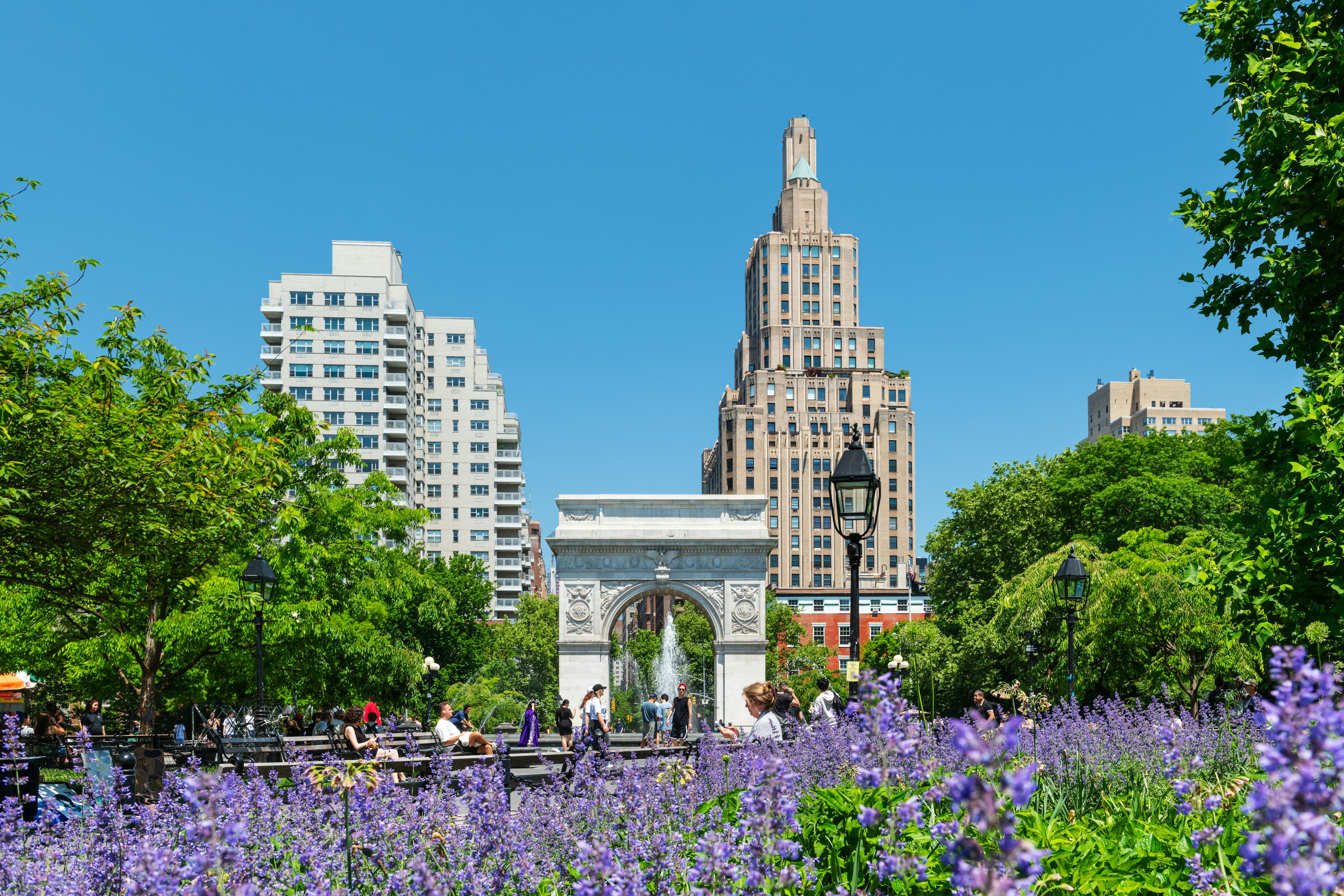 Washington Square Park in Manhattan with the iconic landmark arch and visitors enjoying a sunny spring morning