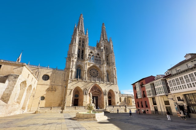 Burgos Cathedral with people and tourists walking in the square next to the Cathedral of Saint Mary, in Burgos, Spain