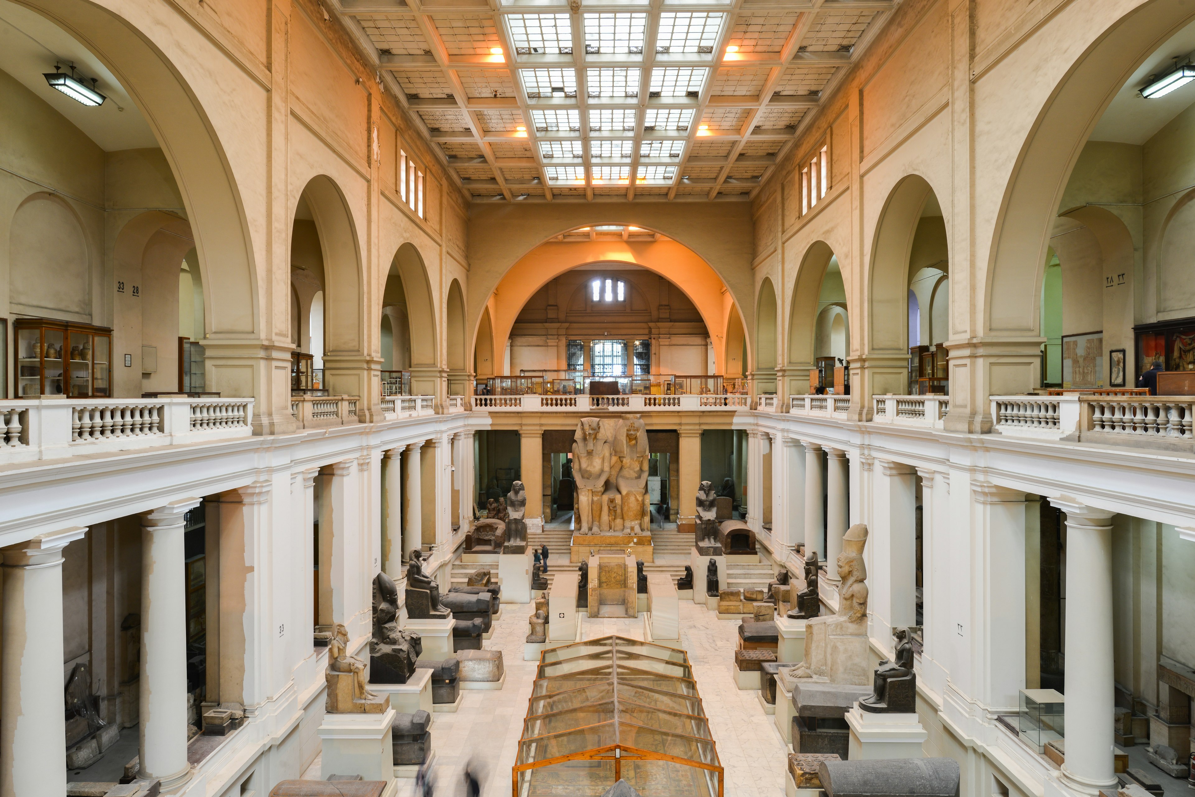 Interior of a vast museum hall displaying Egyptian sculptures and statues