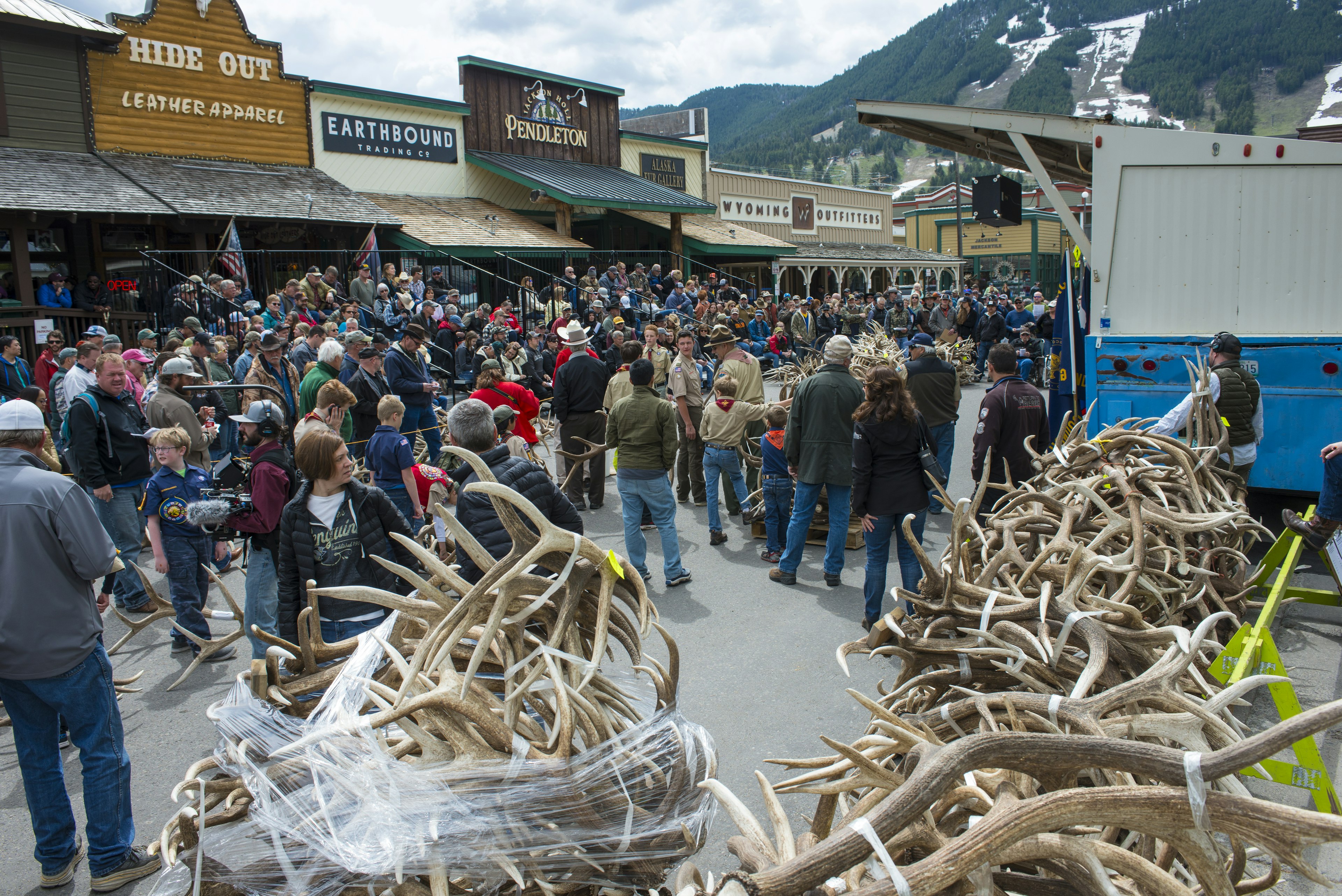 Piles elk antlers in a street as buyers browse at a festival