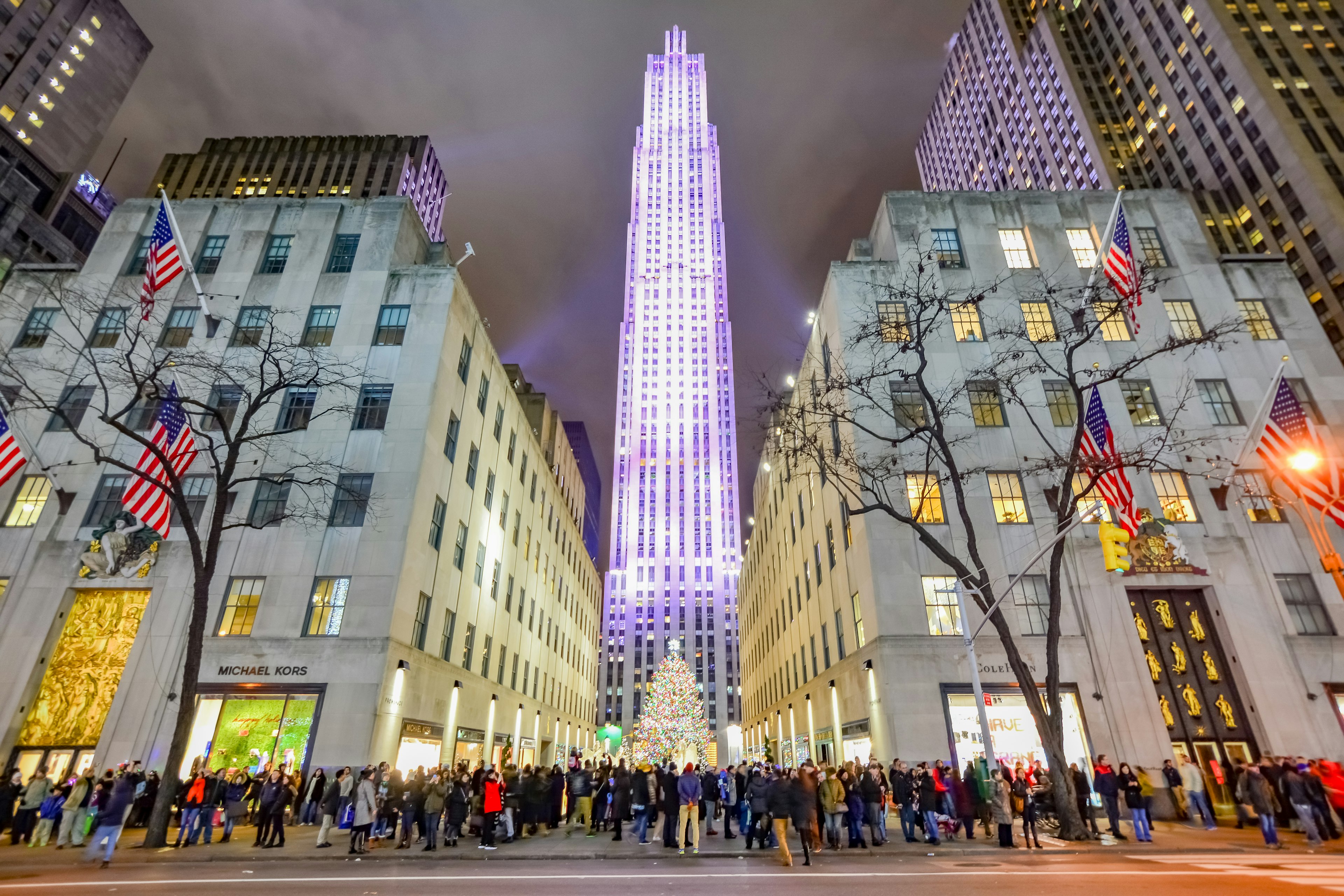 Night in New York City's Rockefeller Center all decorated surrounding the newly lit Christmas tree.