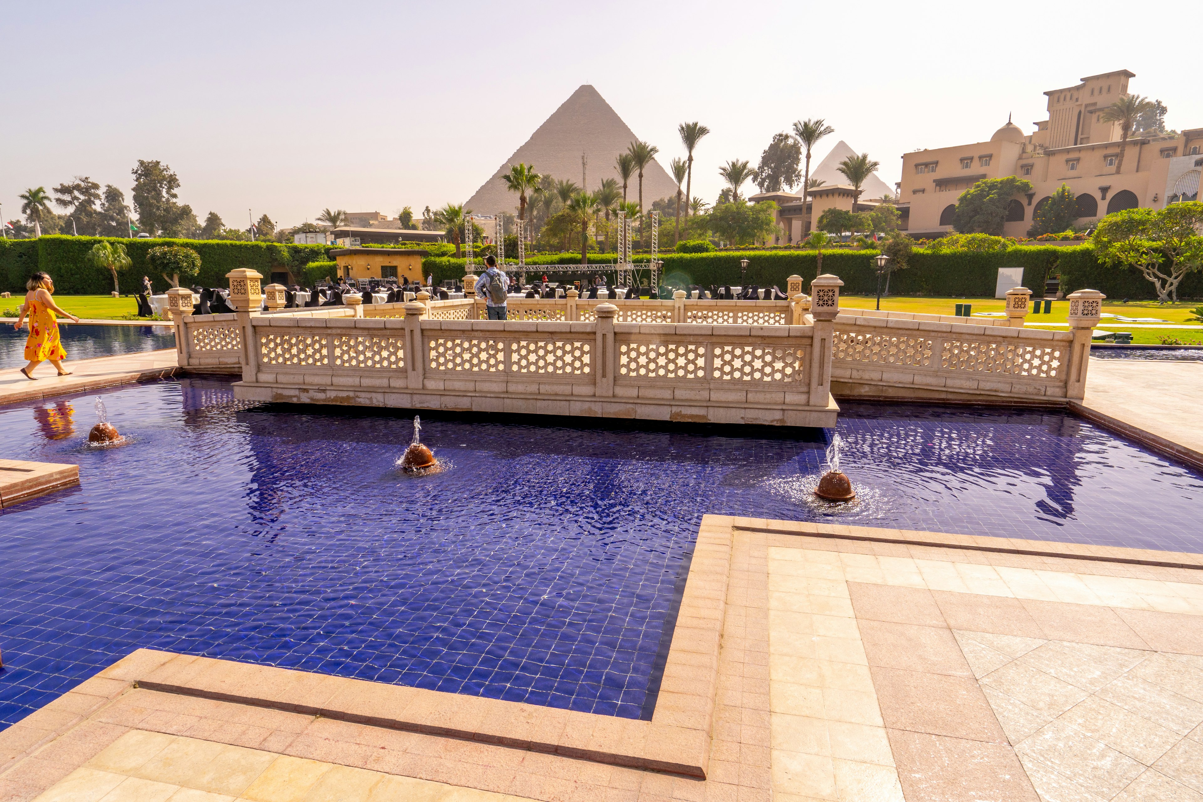 Small pond with fountains and the Cheops pyramid in the background.