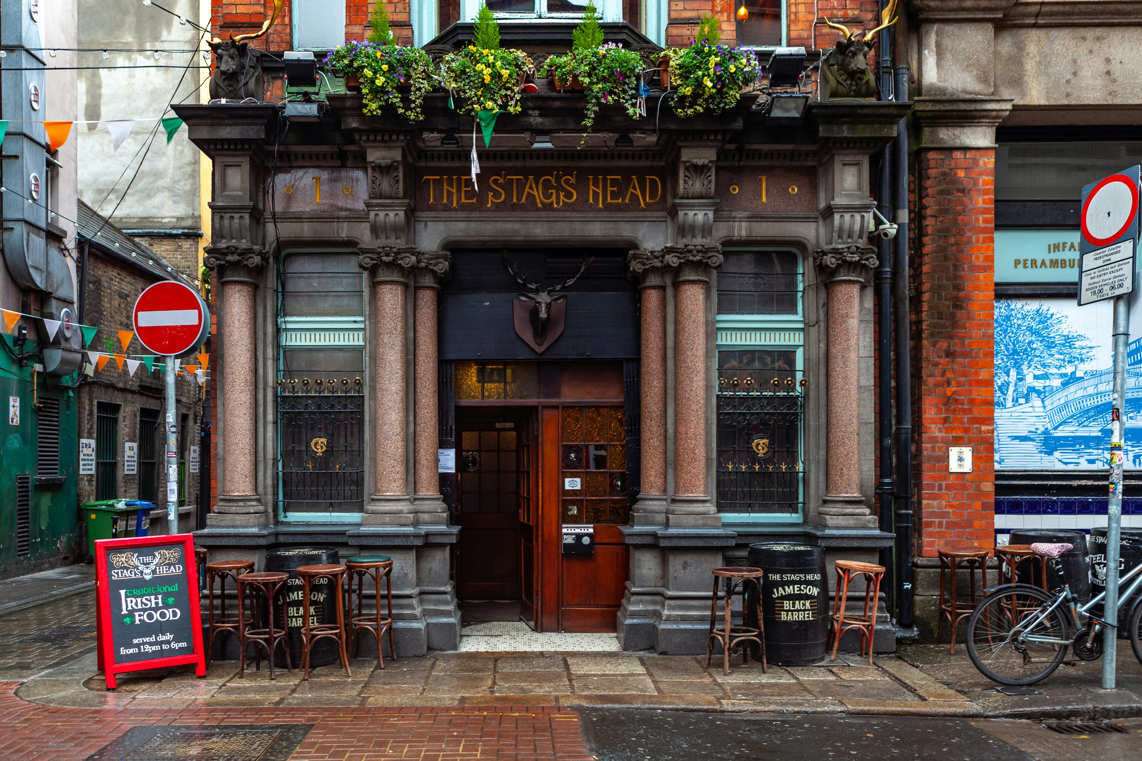 Facade of the Stags Head pub, with traditional barrel and stool seats outside, in Dublin.