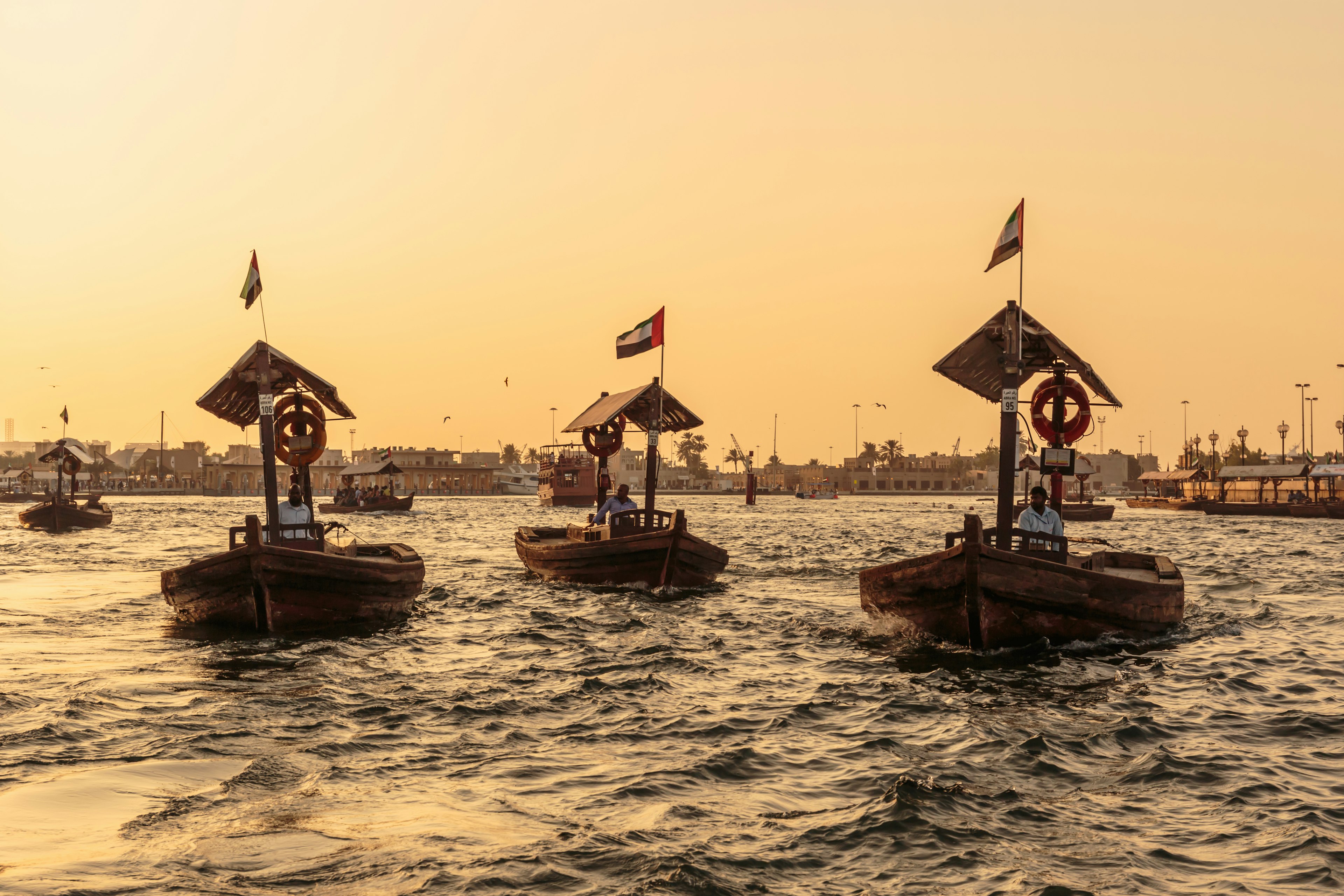 Traditional Abra ferries at sunset in Dubai, UAE.