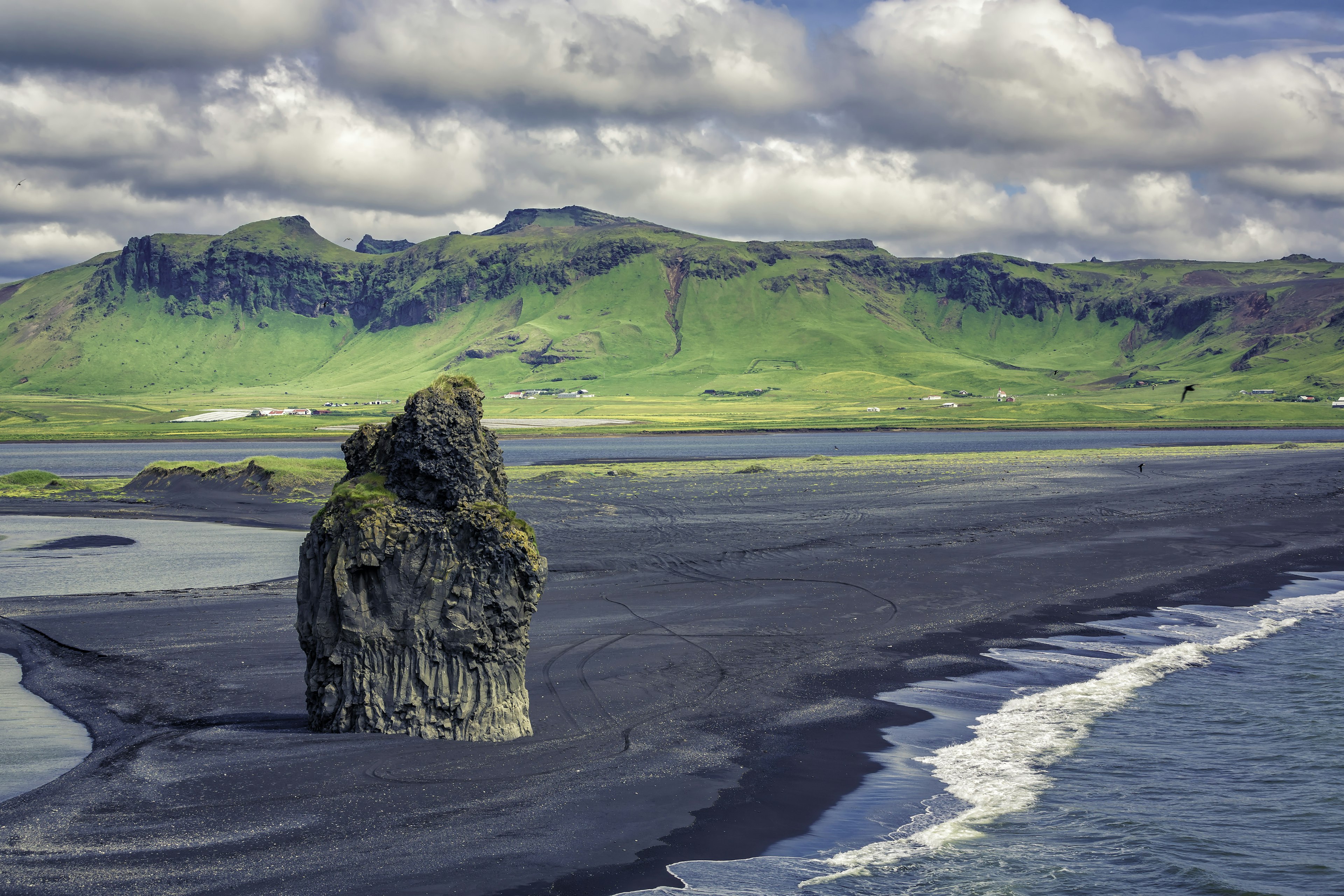 The black sand beach with typical Icelandic mountain landscapes.