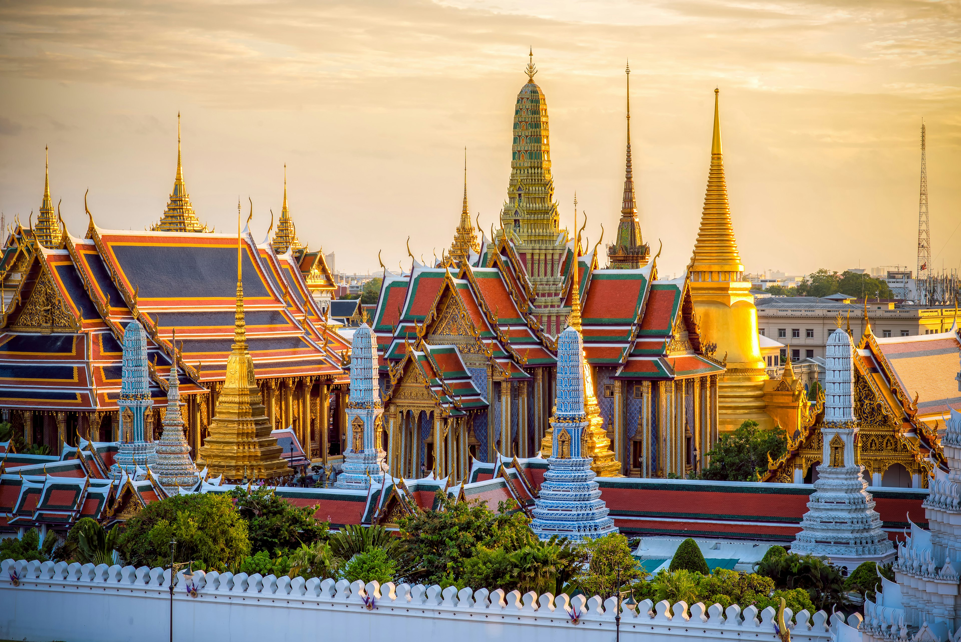 The pointed turrets of a vast grand palace glows golden in the setting sun