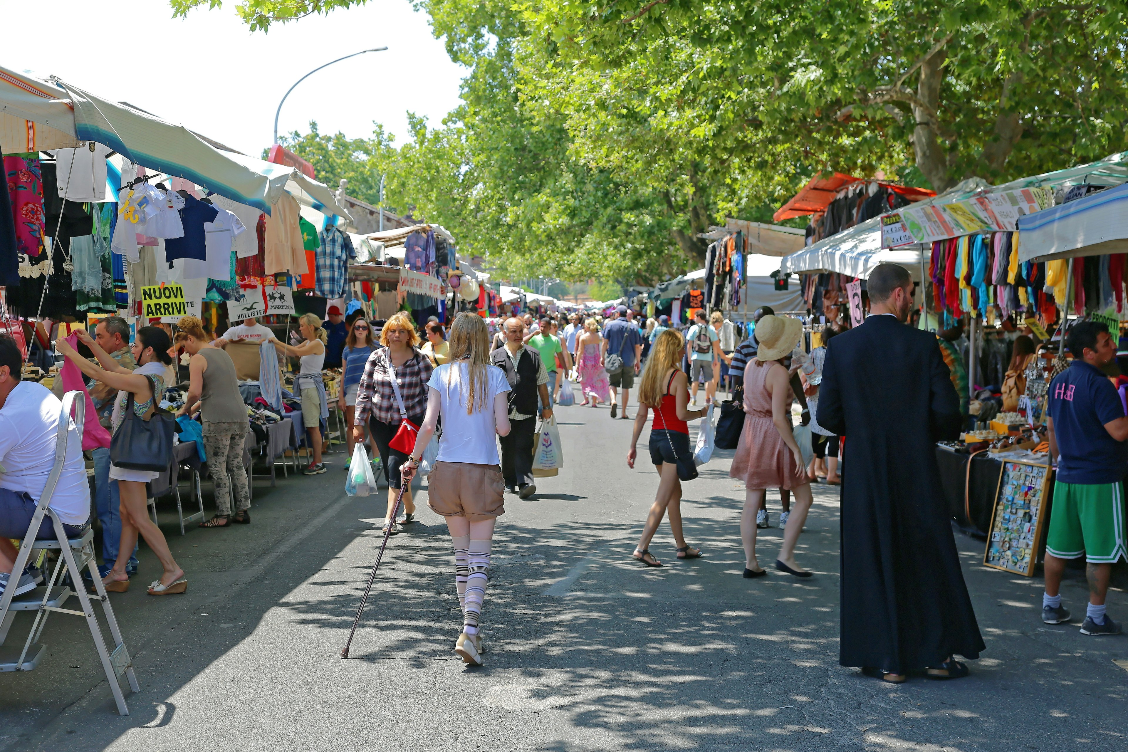 People browsing the stalls at an outdoor vintage market on a sunny day