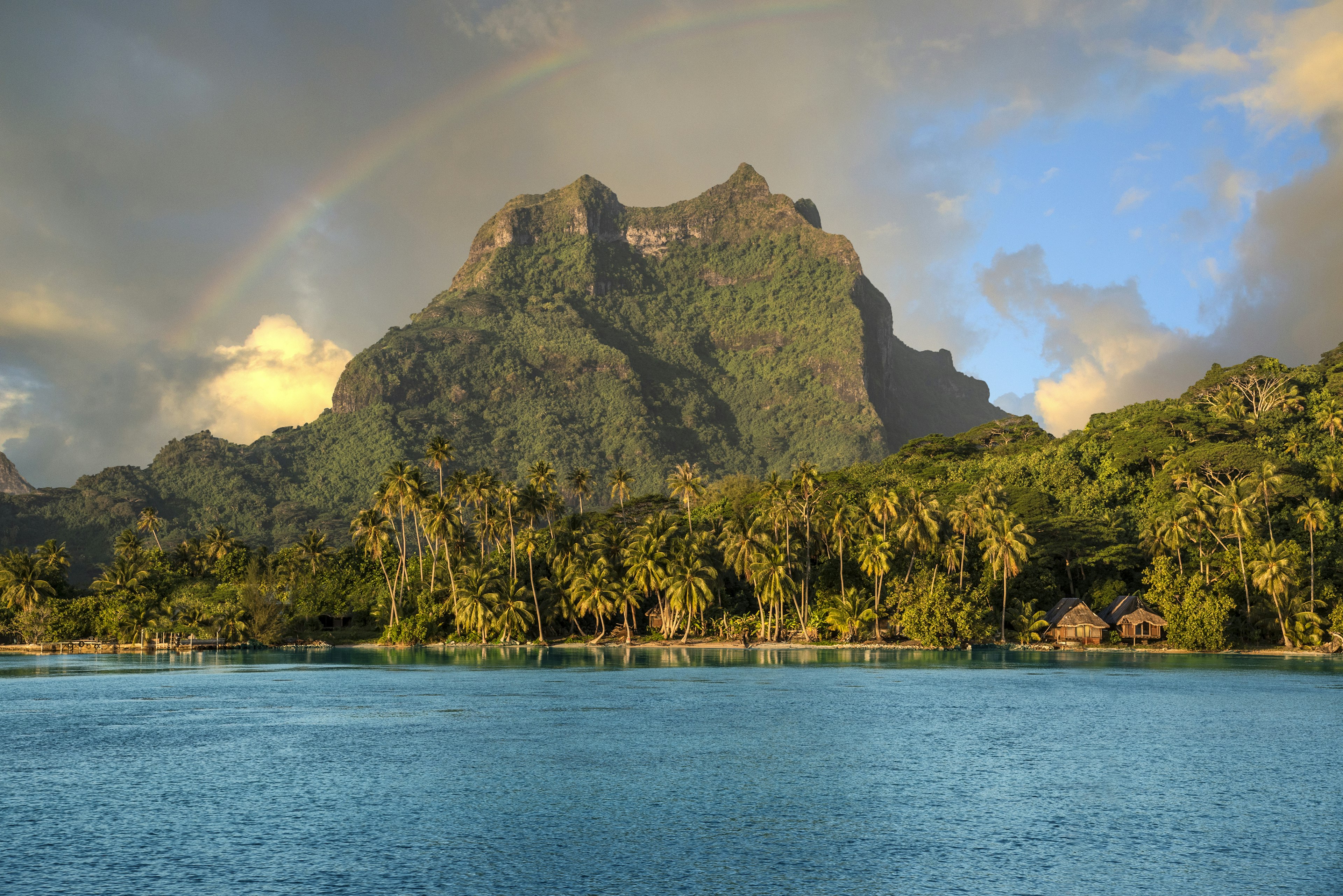 A rainbow breaking over the mountains in Bora Bora, French Polynesia.