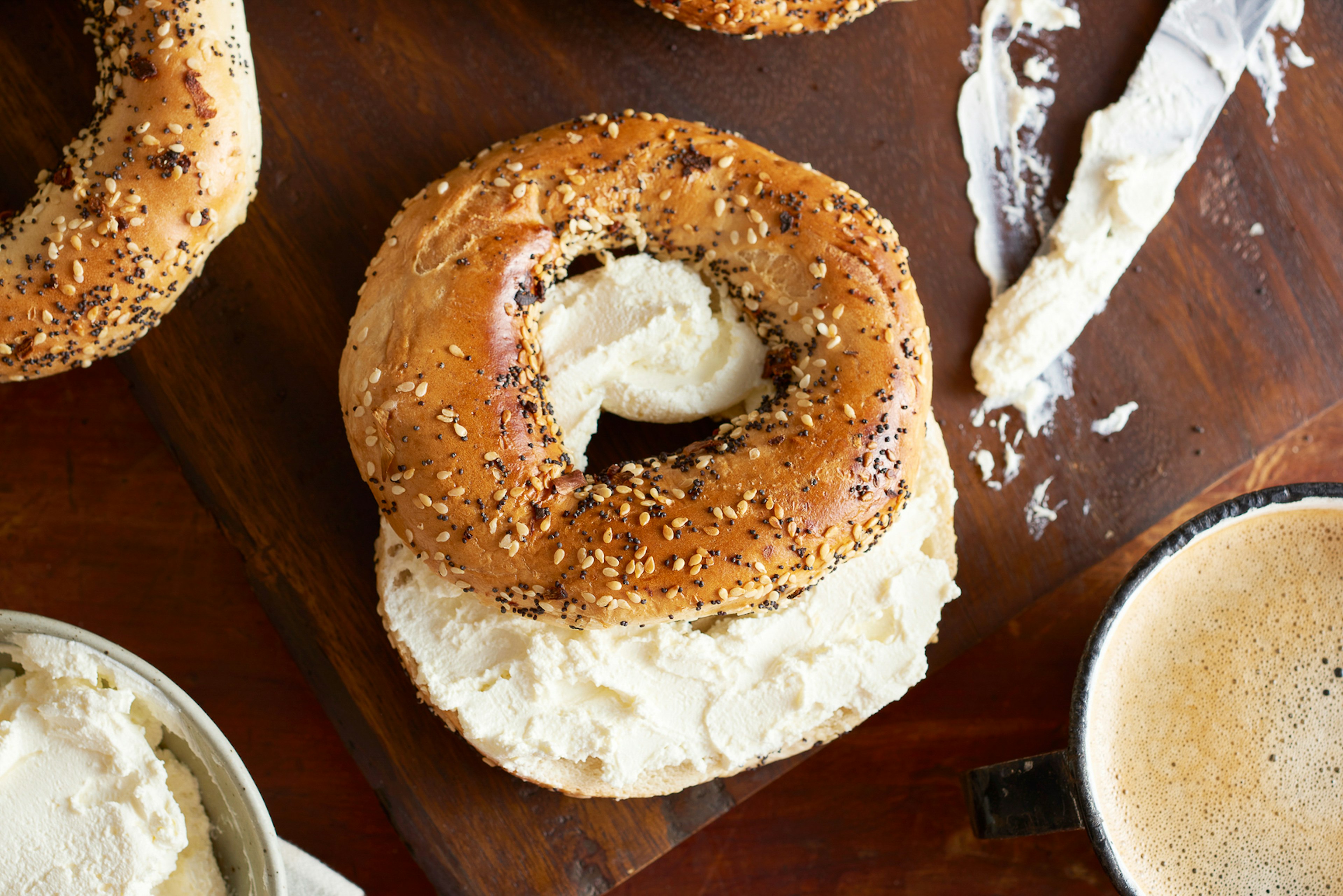 Fresh bagels and cream cheese with everything on them for breakfast.