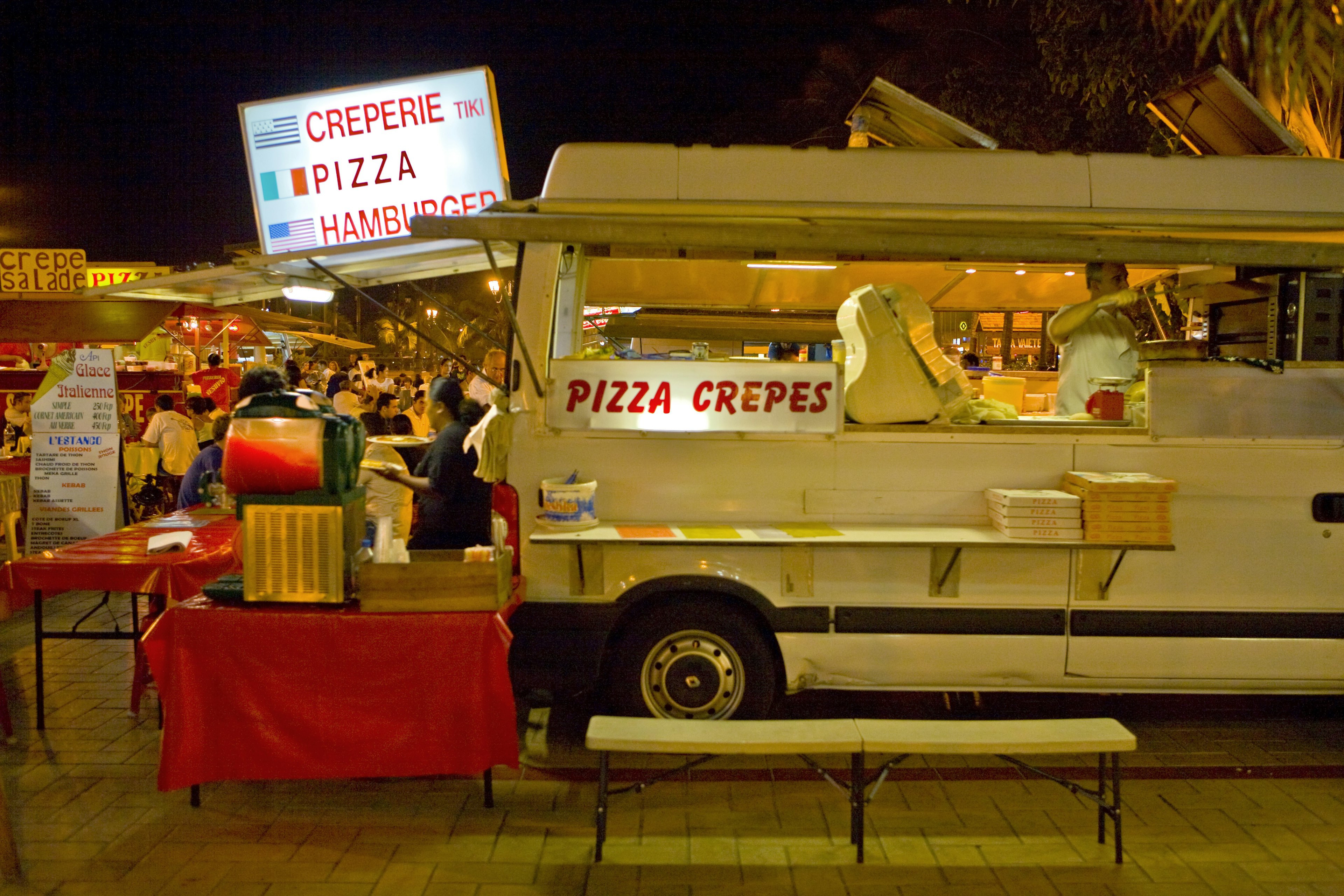 Food trucks, called roulottes, serve foods to people who take seats nearby