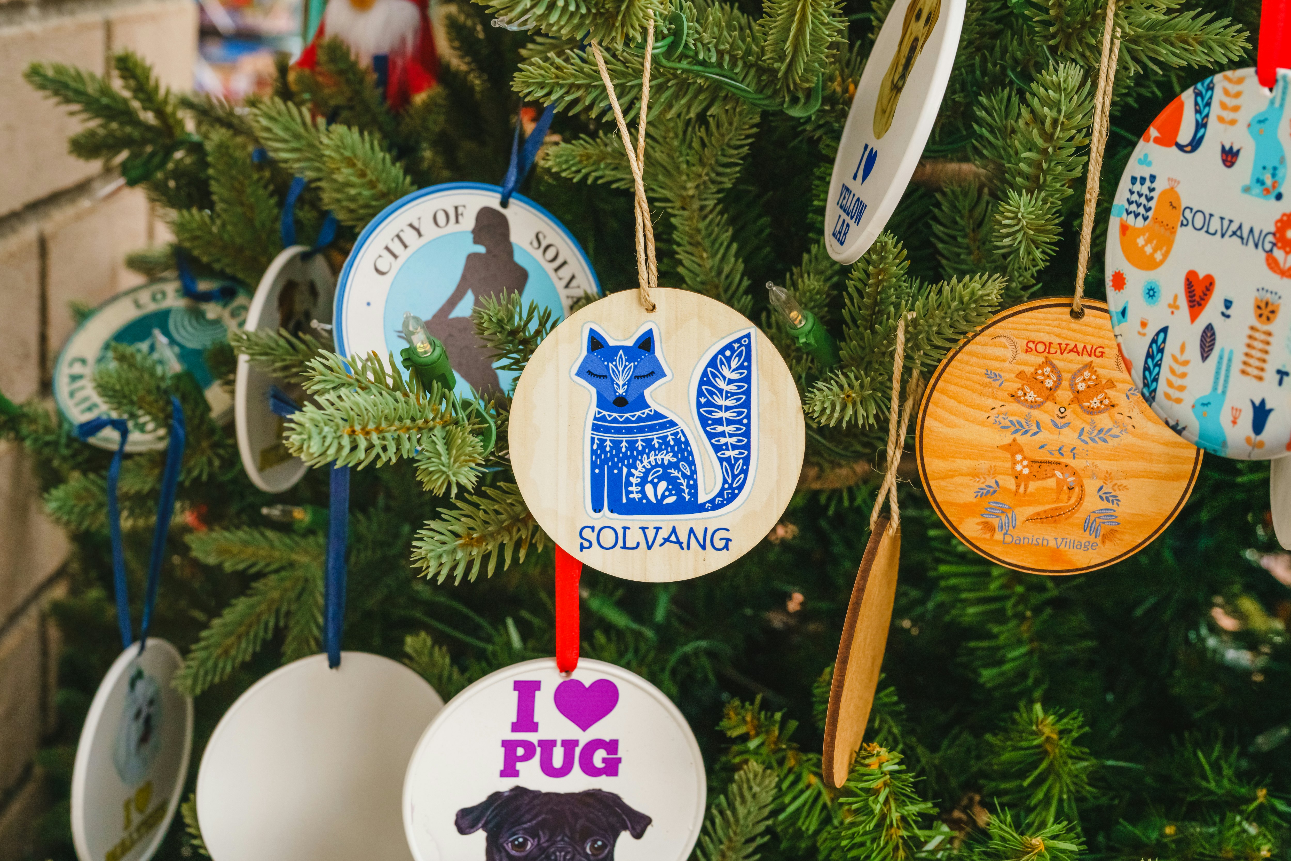 Individual wooden tree decorations that say "Solvang"