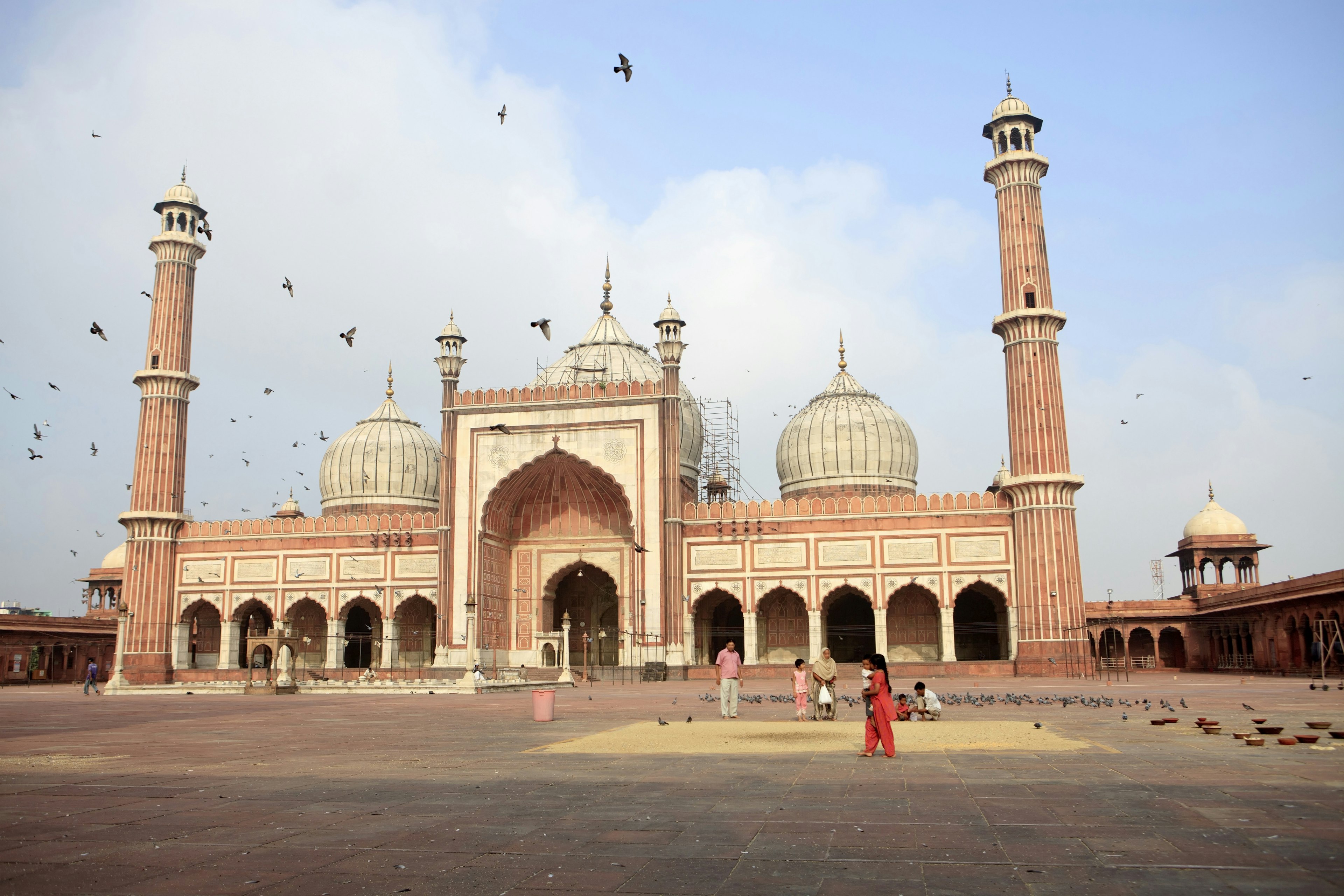 Children feeding pigeons outside Jama Masjid in the early morning.