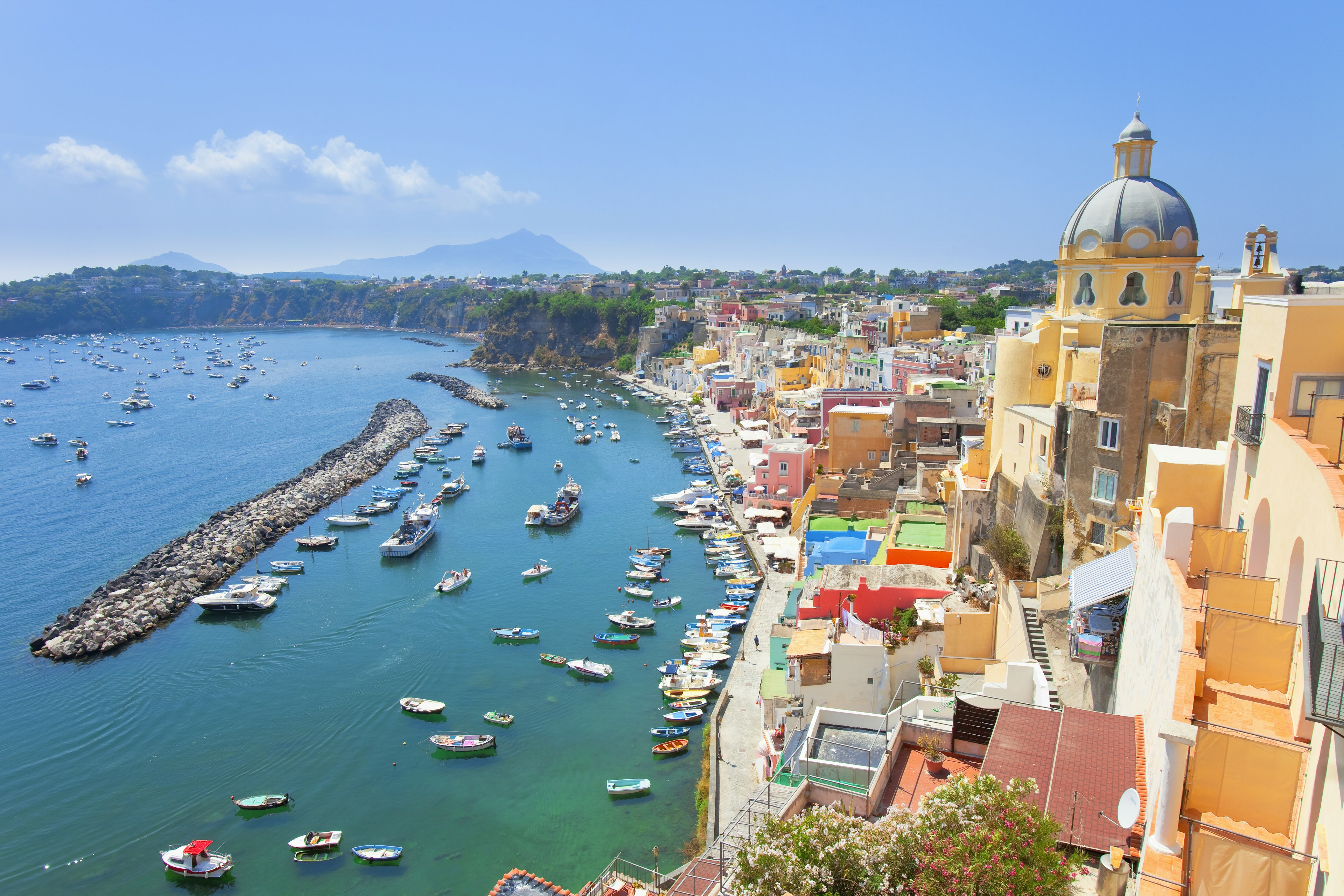 A small harbor in front of a town with pastel-painted buildings