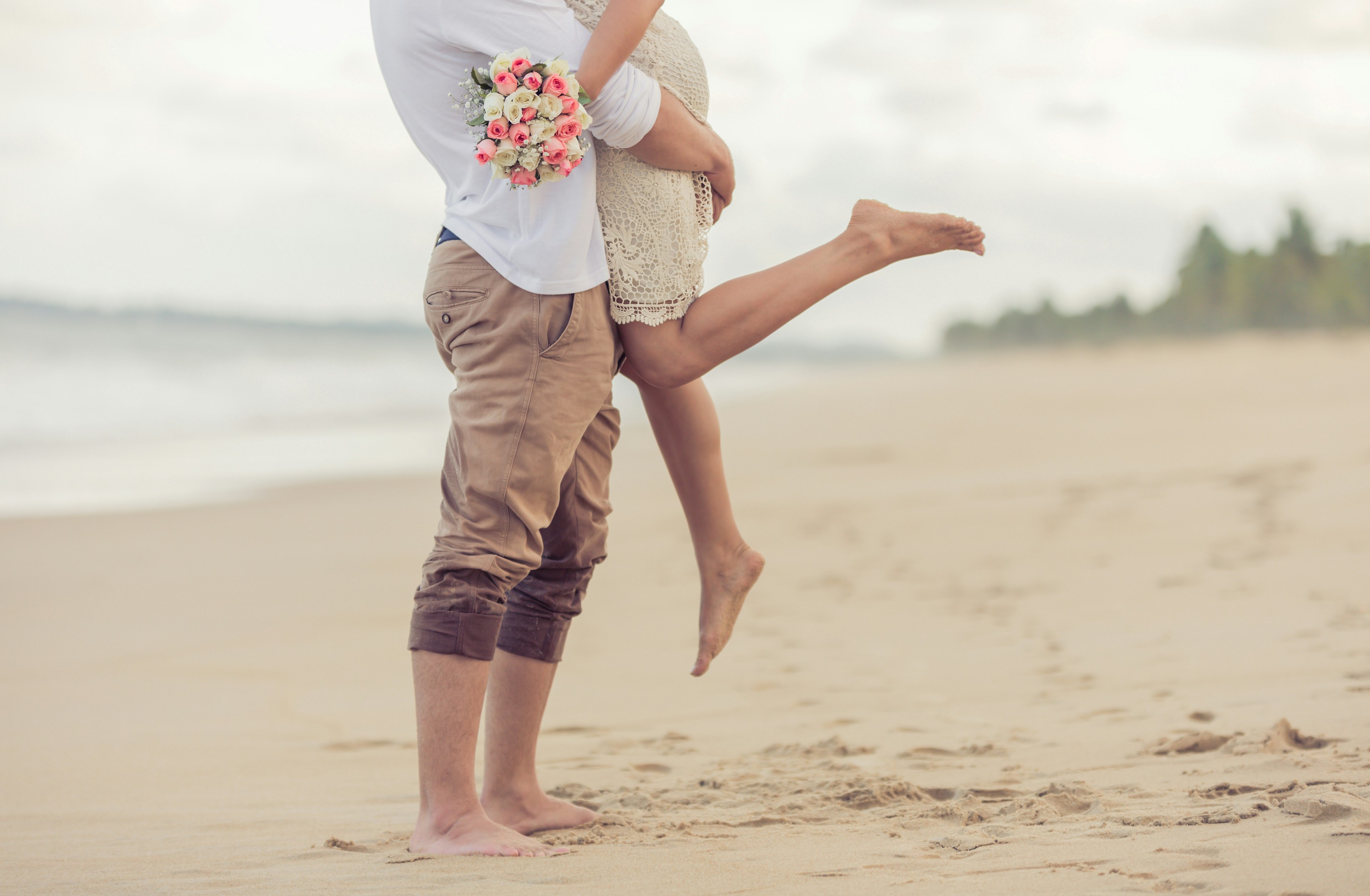 A couple embrace on the beach.