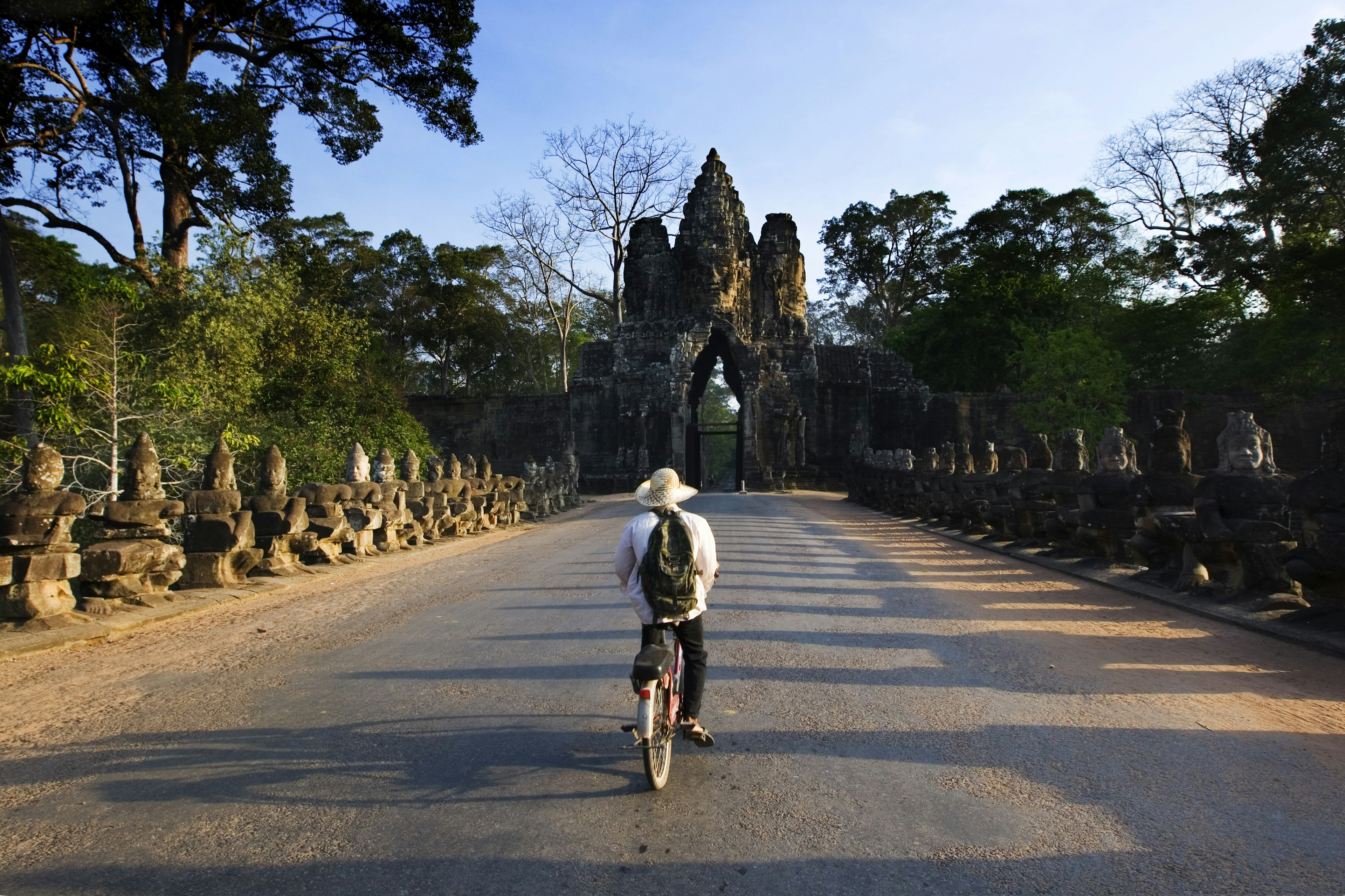 A cyclist approached a carved gateway at Angkor, Cambodia.