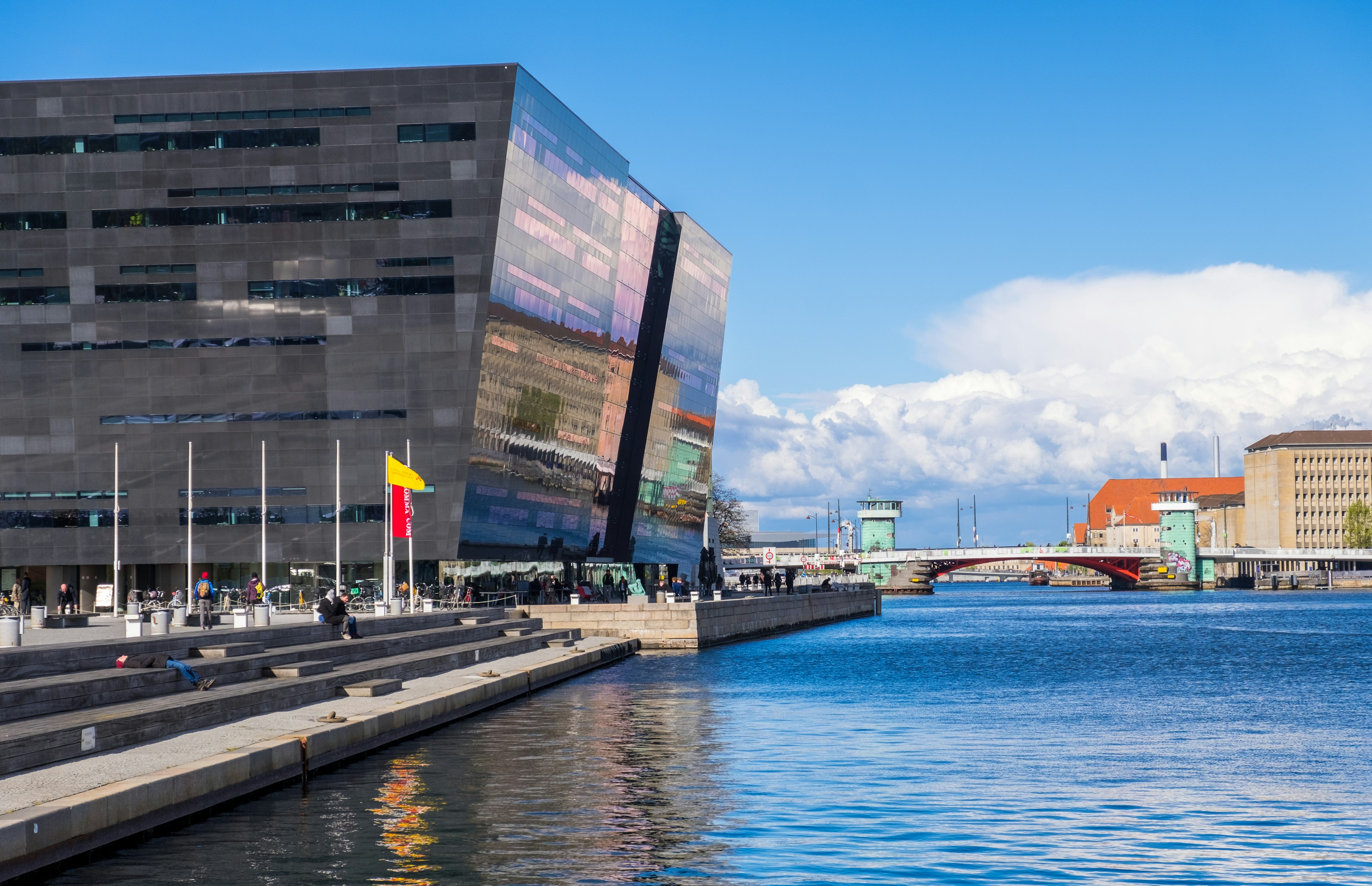 People relax by the Black Diamond, the national library of Denmark