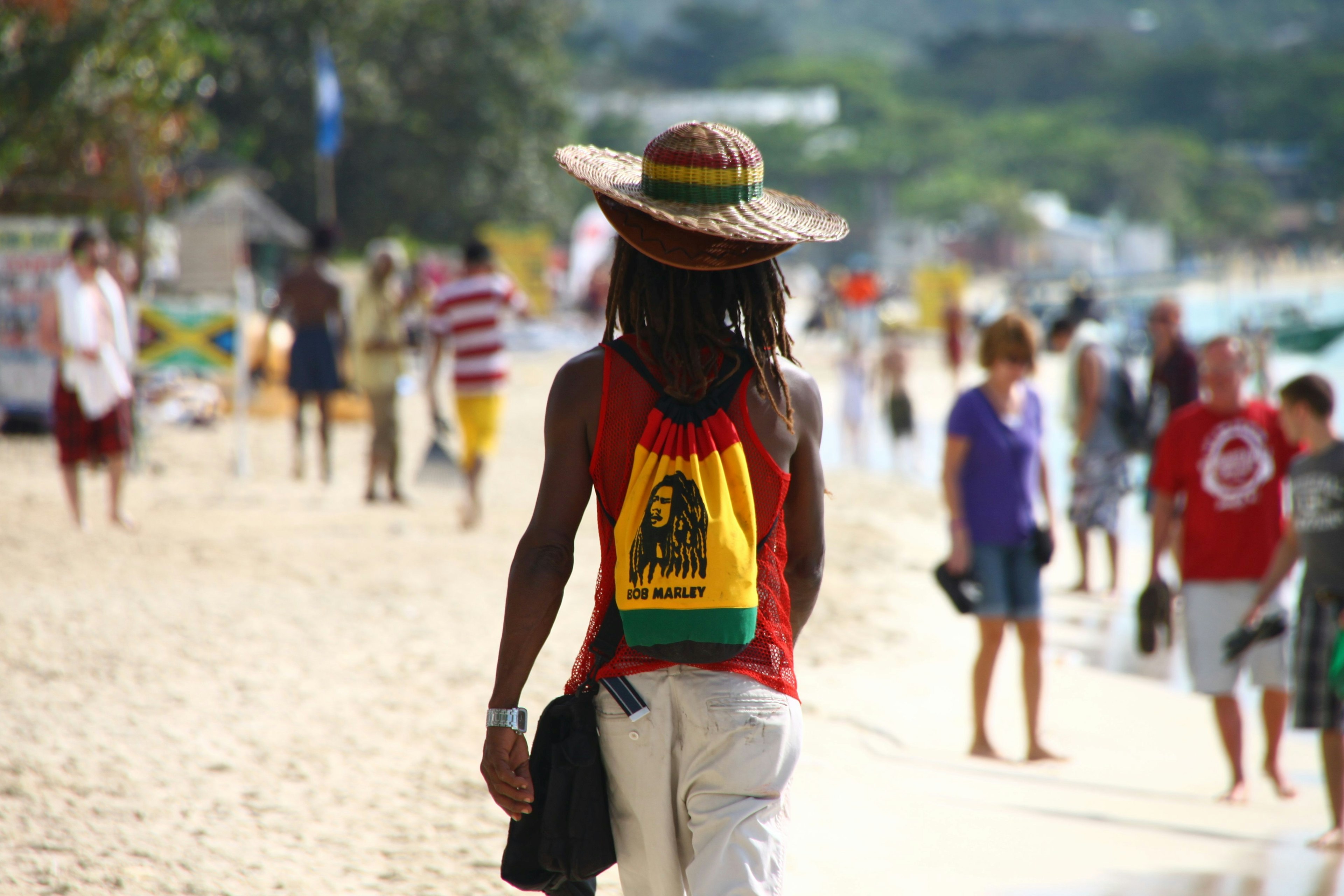 A man walking along Seven Mile Beach in Negril, Jamaica