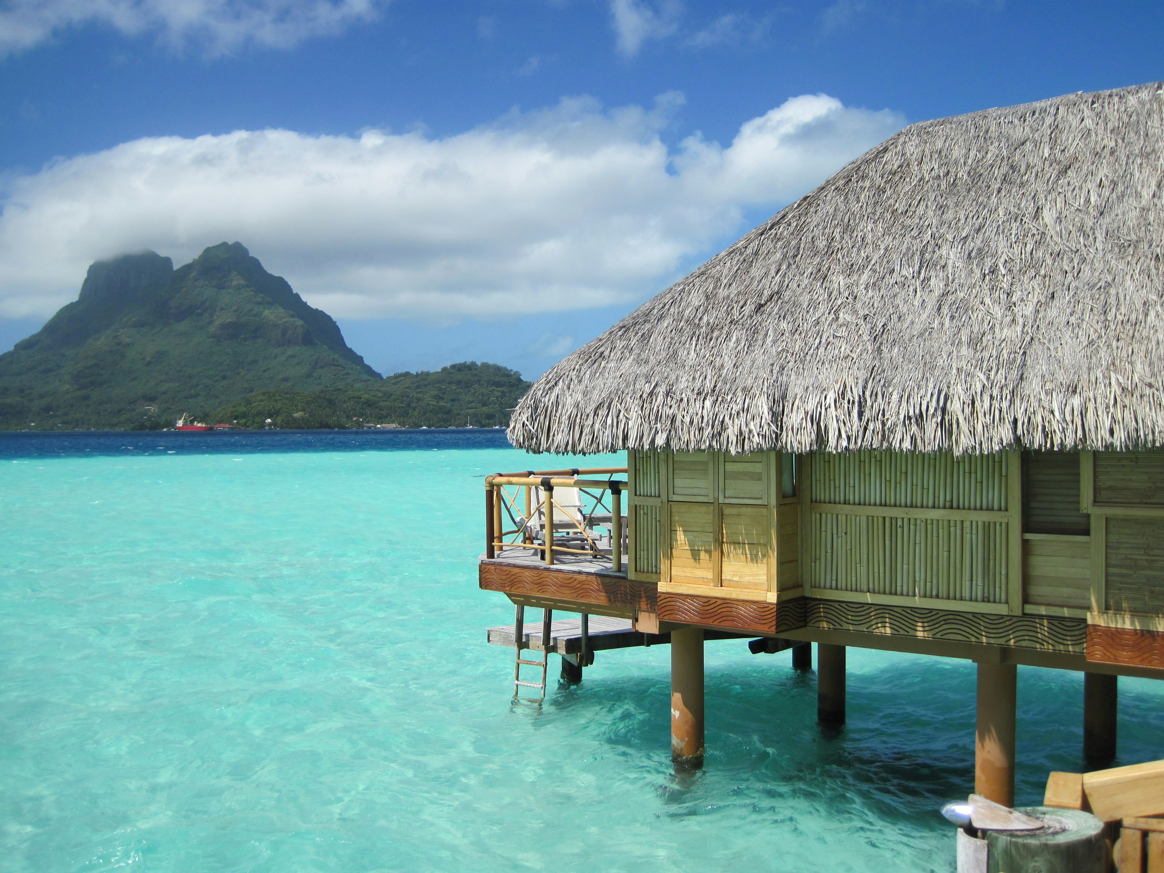 View of an overwater bungalow and Mount Otemanu in the background in Bora Bora, French Polynesia.