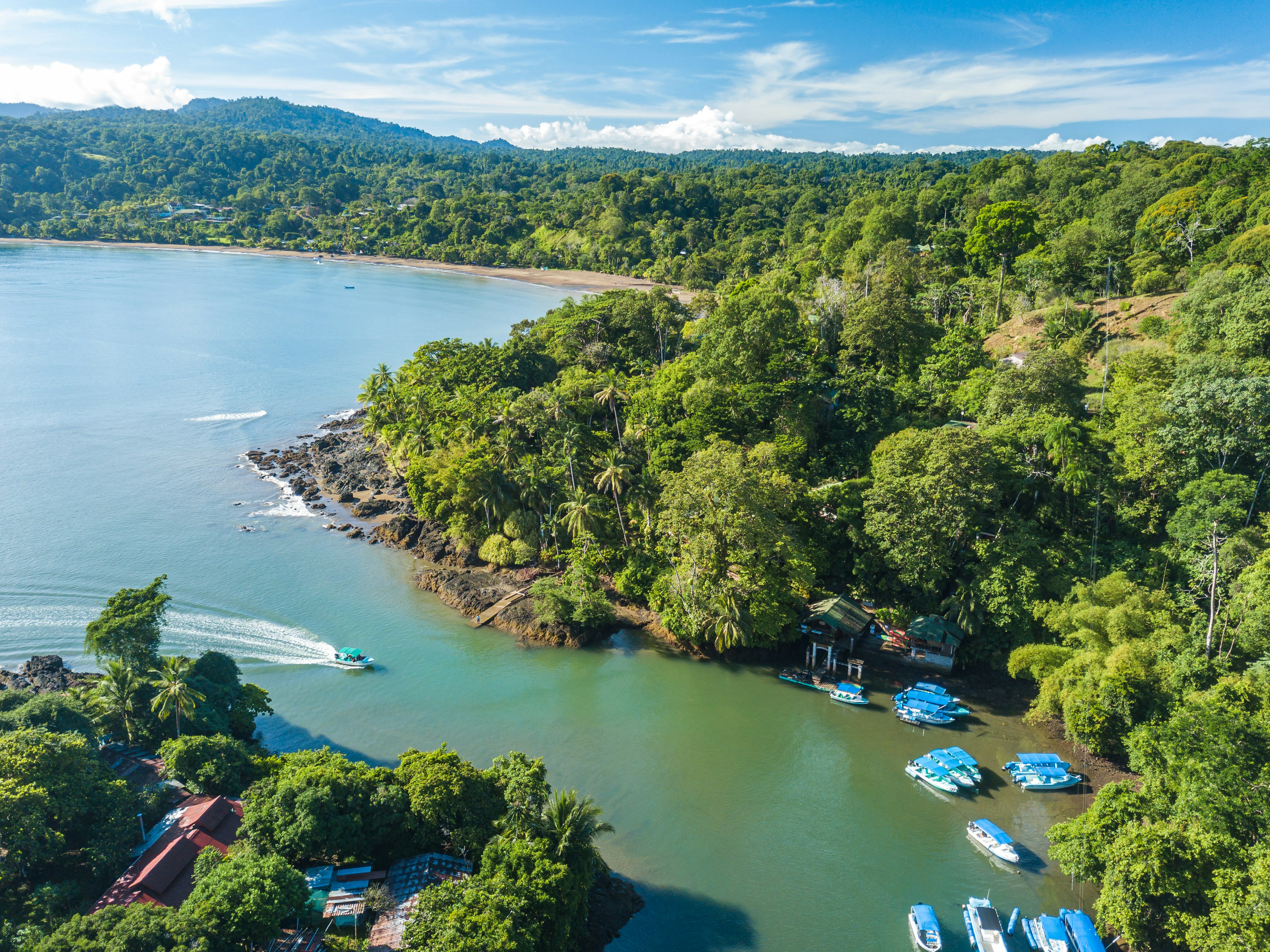 Aerial drone shot of famous Drake Bay near Corcovado National Park at river mouth with boat dock.