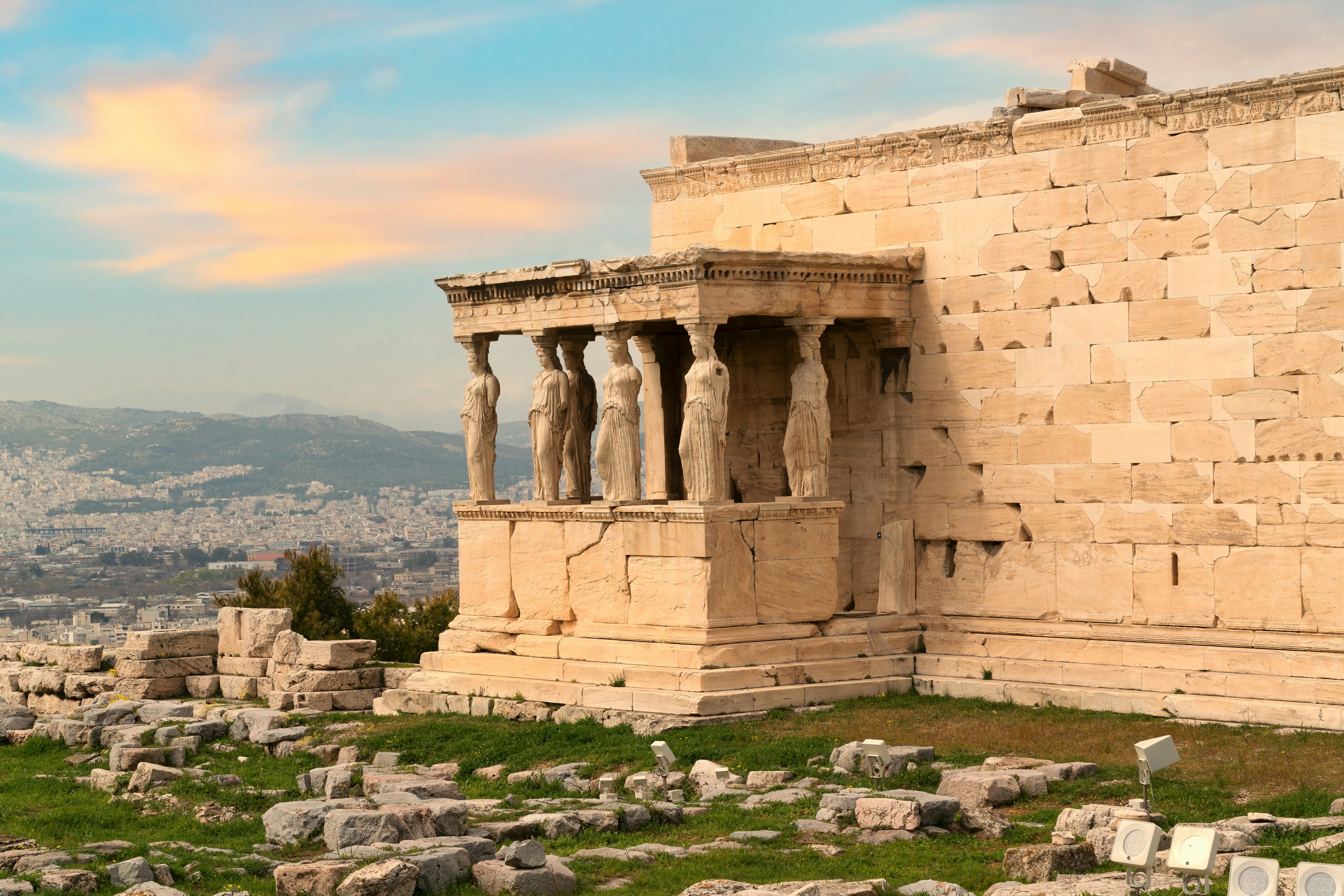 A large ancient temple on a hilltip with huge caryatid statues acting as columns