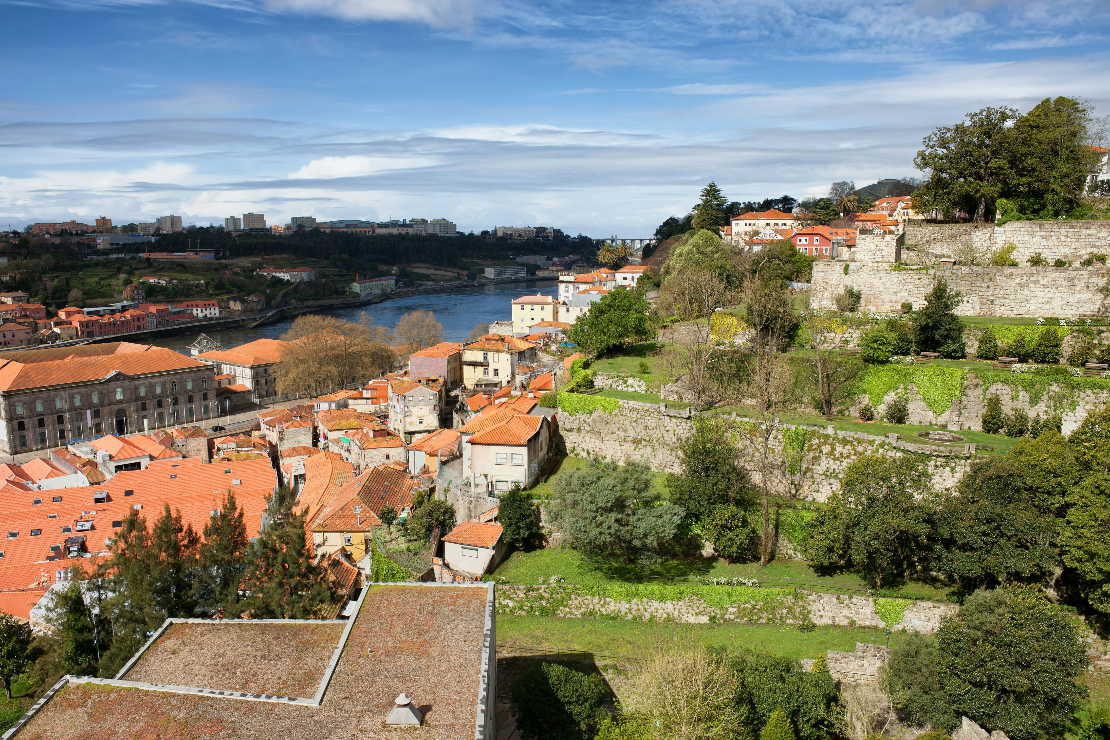 Terraced gardens above red-roof buildings on a steep riverbank.