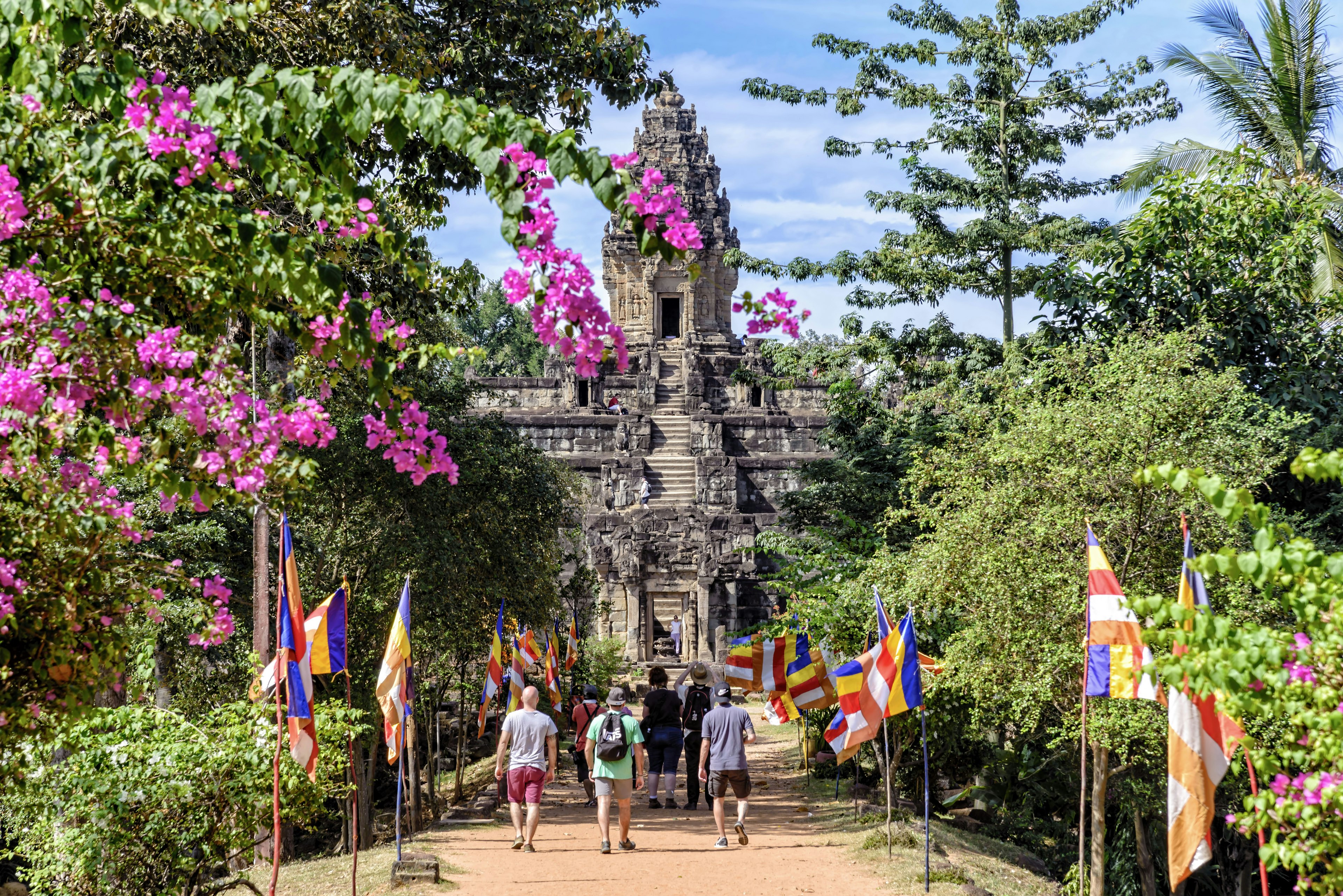 A group of tourists approaching the Bakong temple at Angkor, Cambodia.