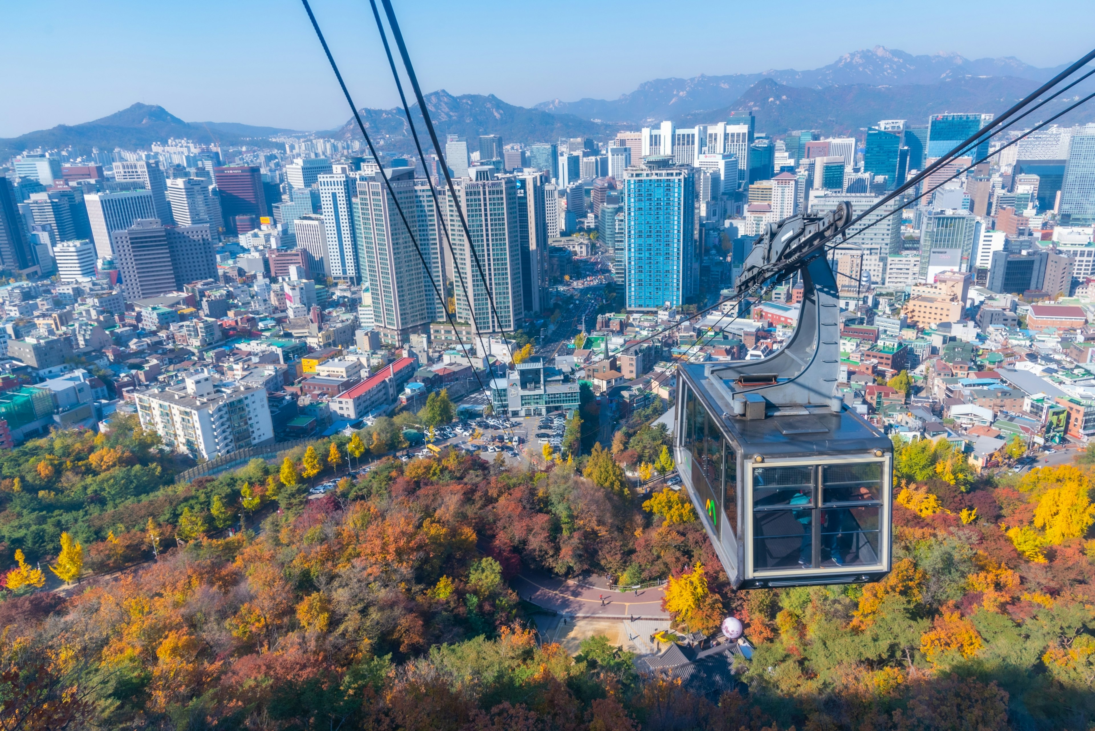 A cable car rises above a high-rise city