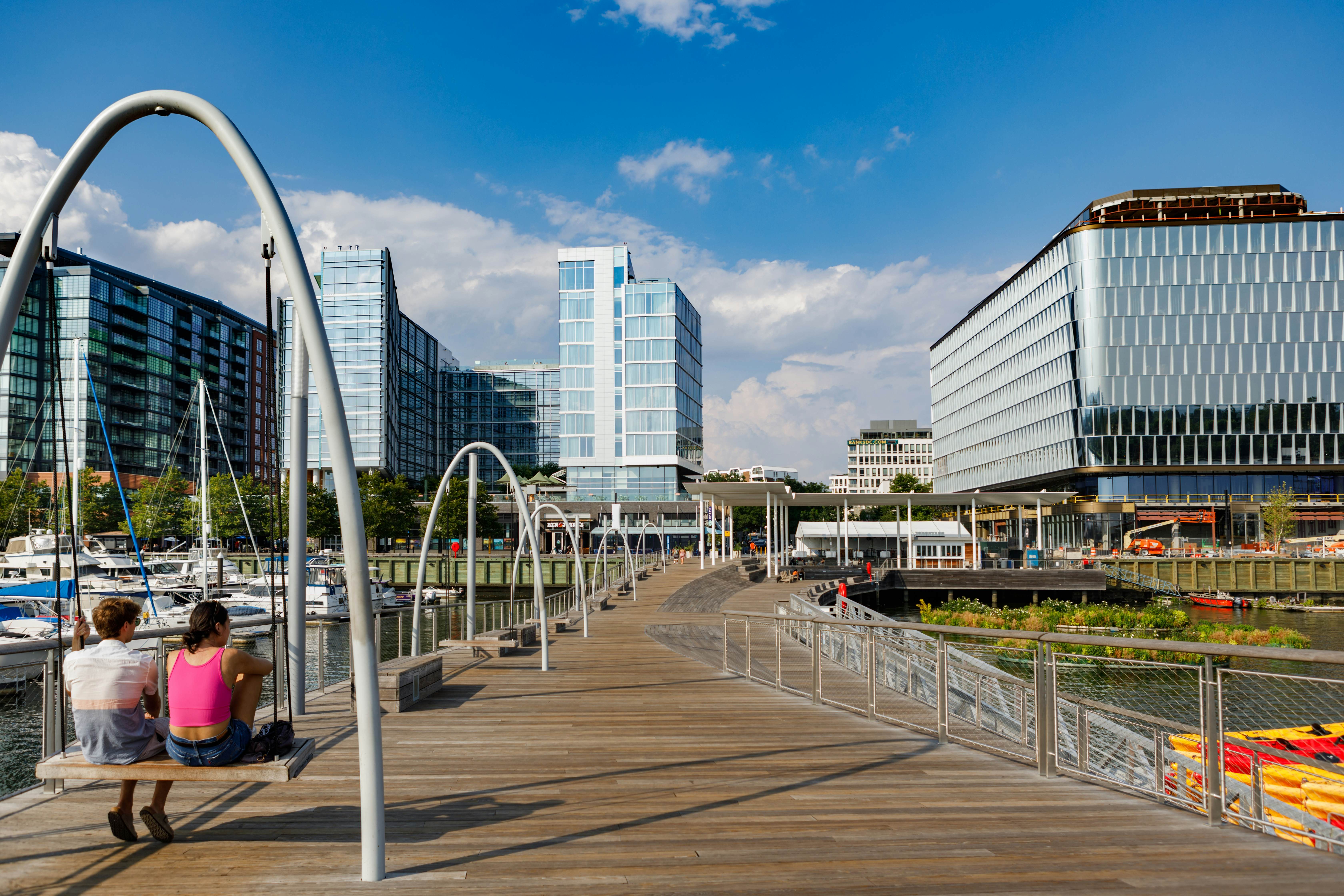 Tourists enjoying a relaxing swing at Recreation Pier in the renovated Southwest Wharf neighborhood in Washington, DC.