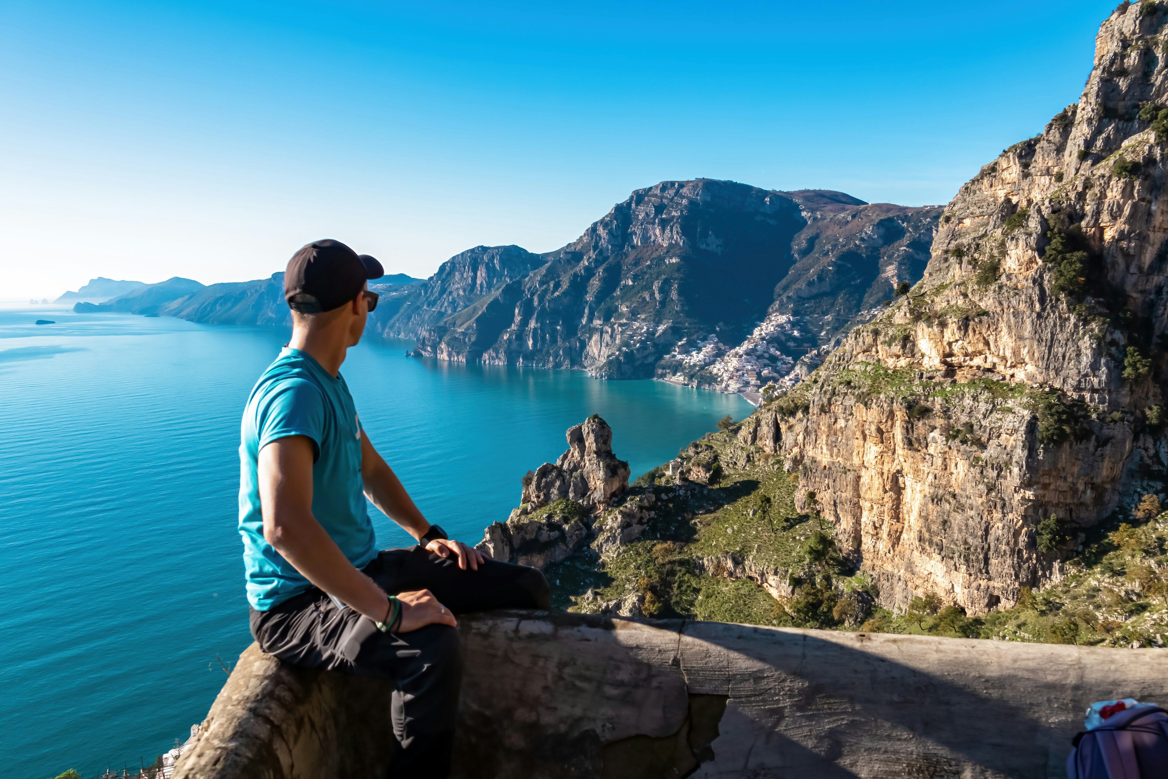 Man with panoramic view from hiking trail Path of Gods between coastal towns Positano and Praiano.