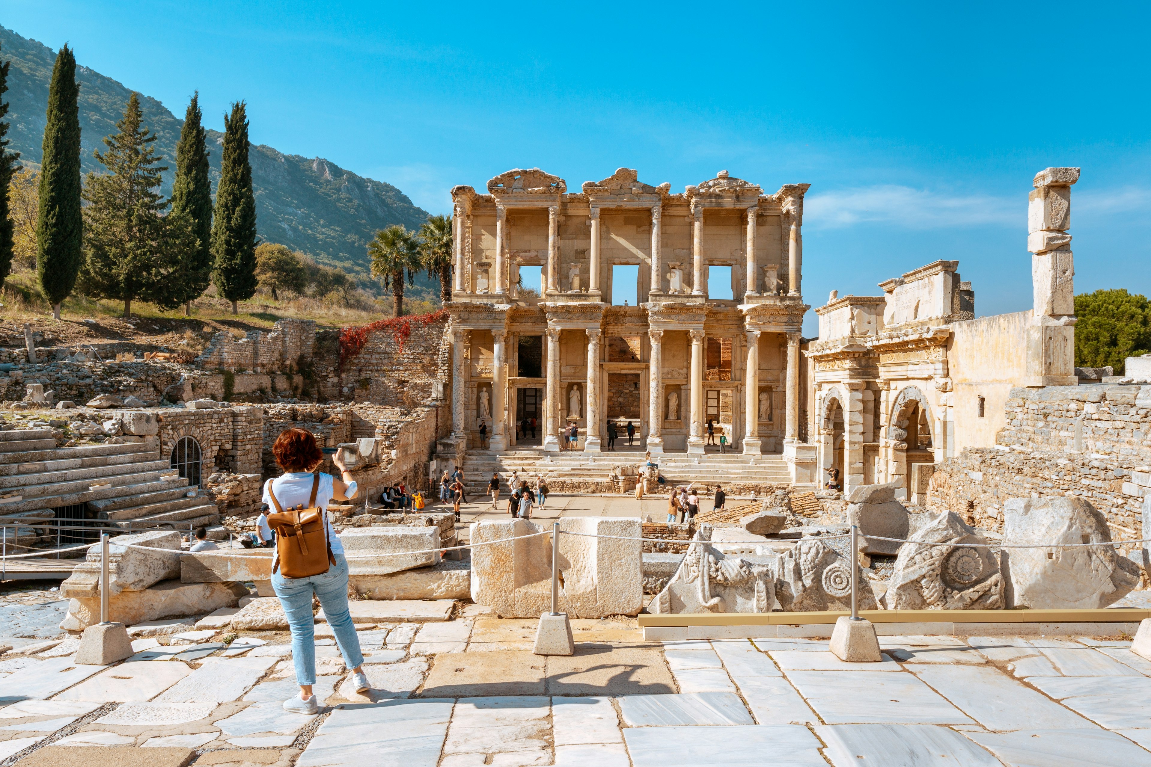 A woman taking photos of the Library of Celsus at Ephesus, Turkey.
