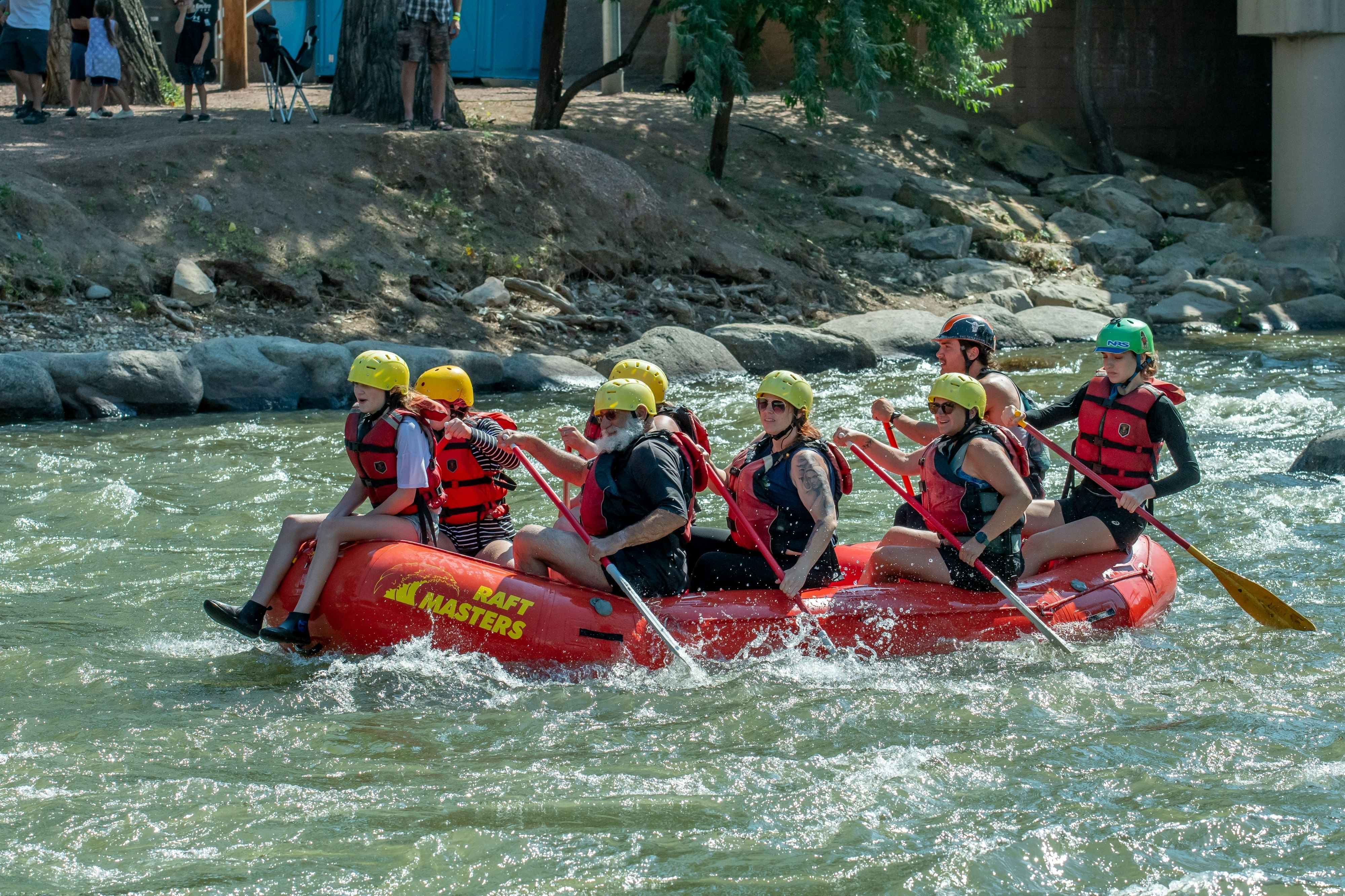 A raft full of people paddling down a white water river