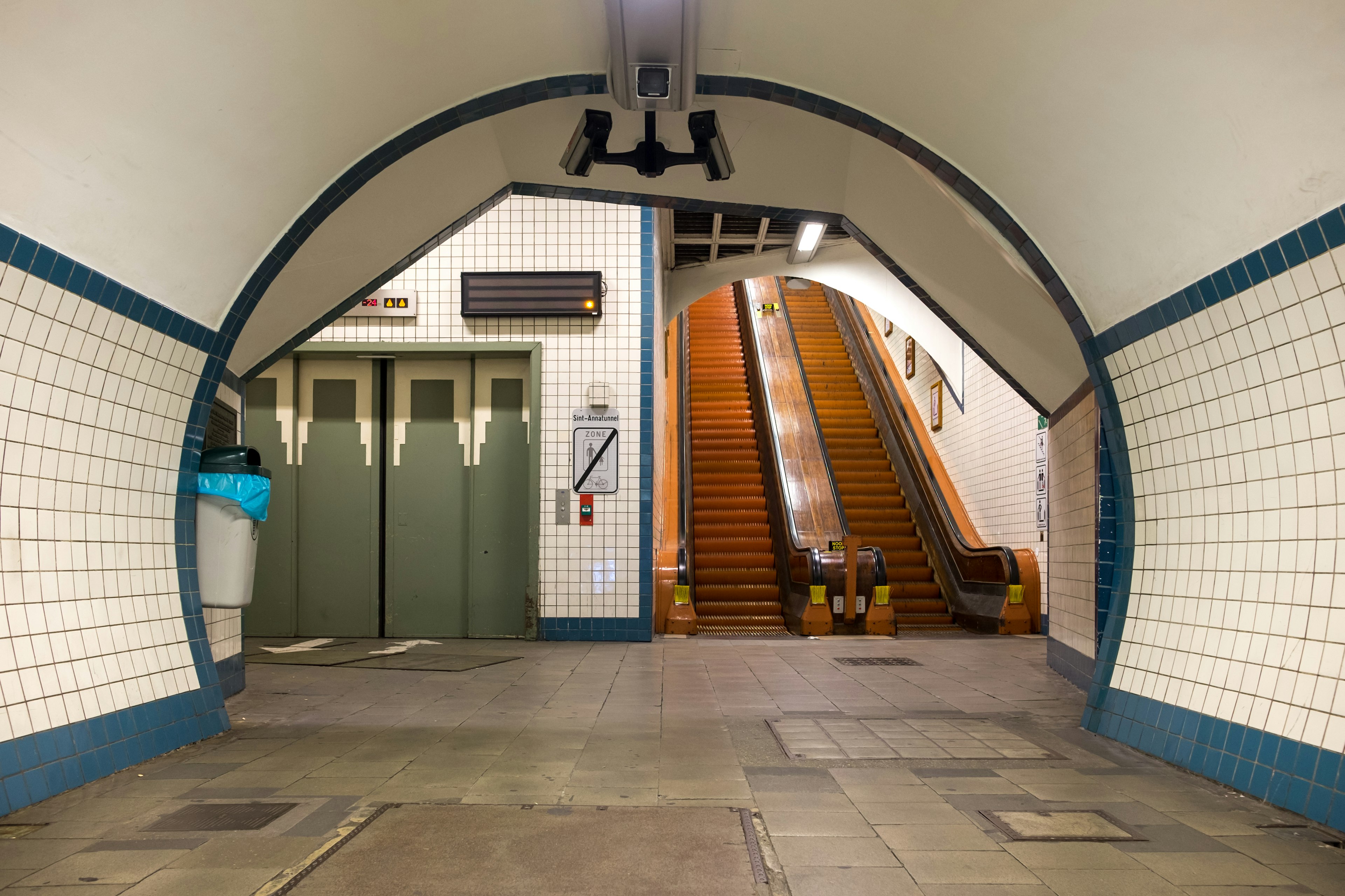 A tunnel leading to two wooden escalators in the art deco style