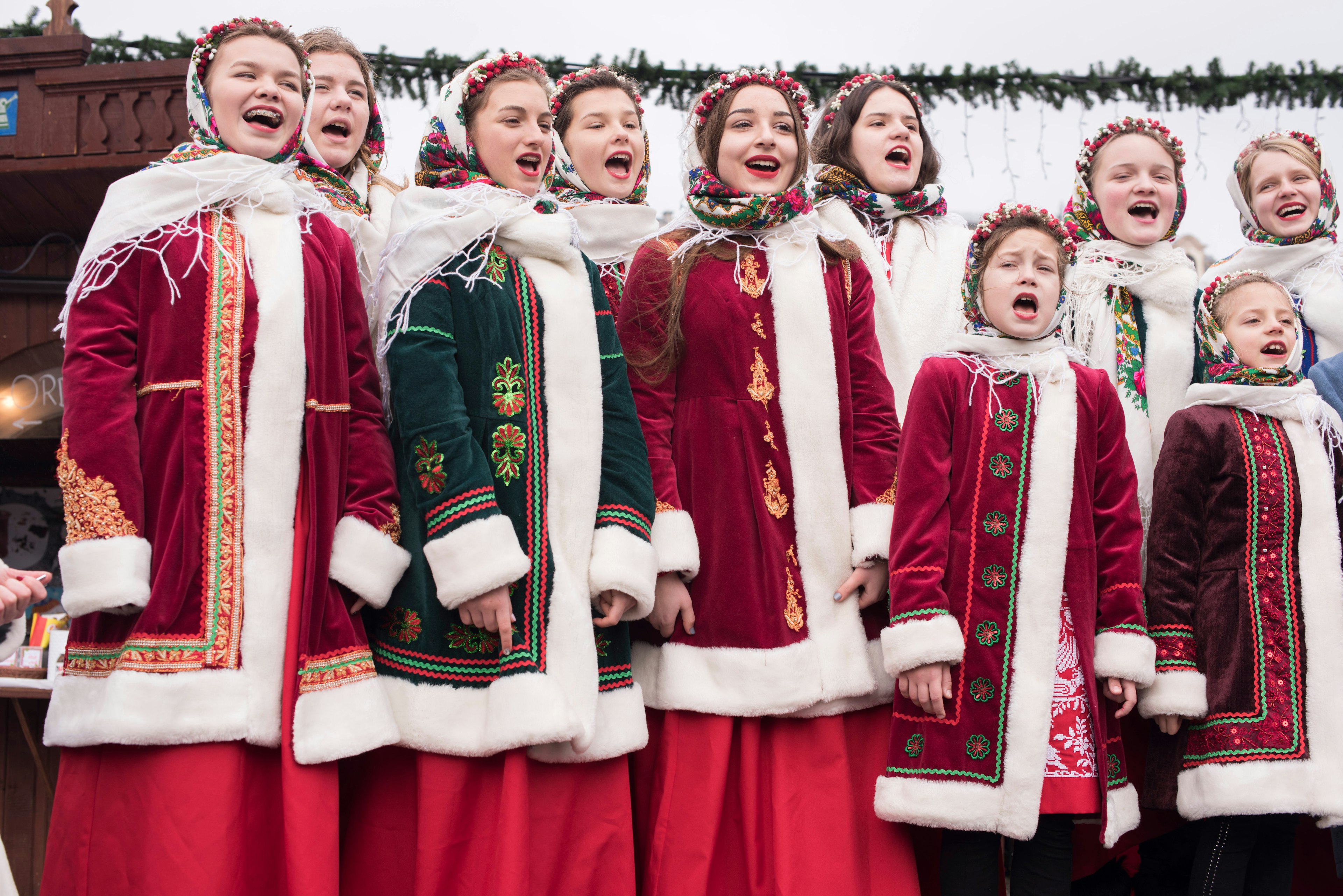 Polish children dressed in traditional costume singing Christmas carols to a gathering of people in the Main Market Square in Old Town, Krakow, Poland.