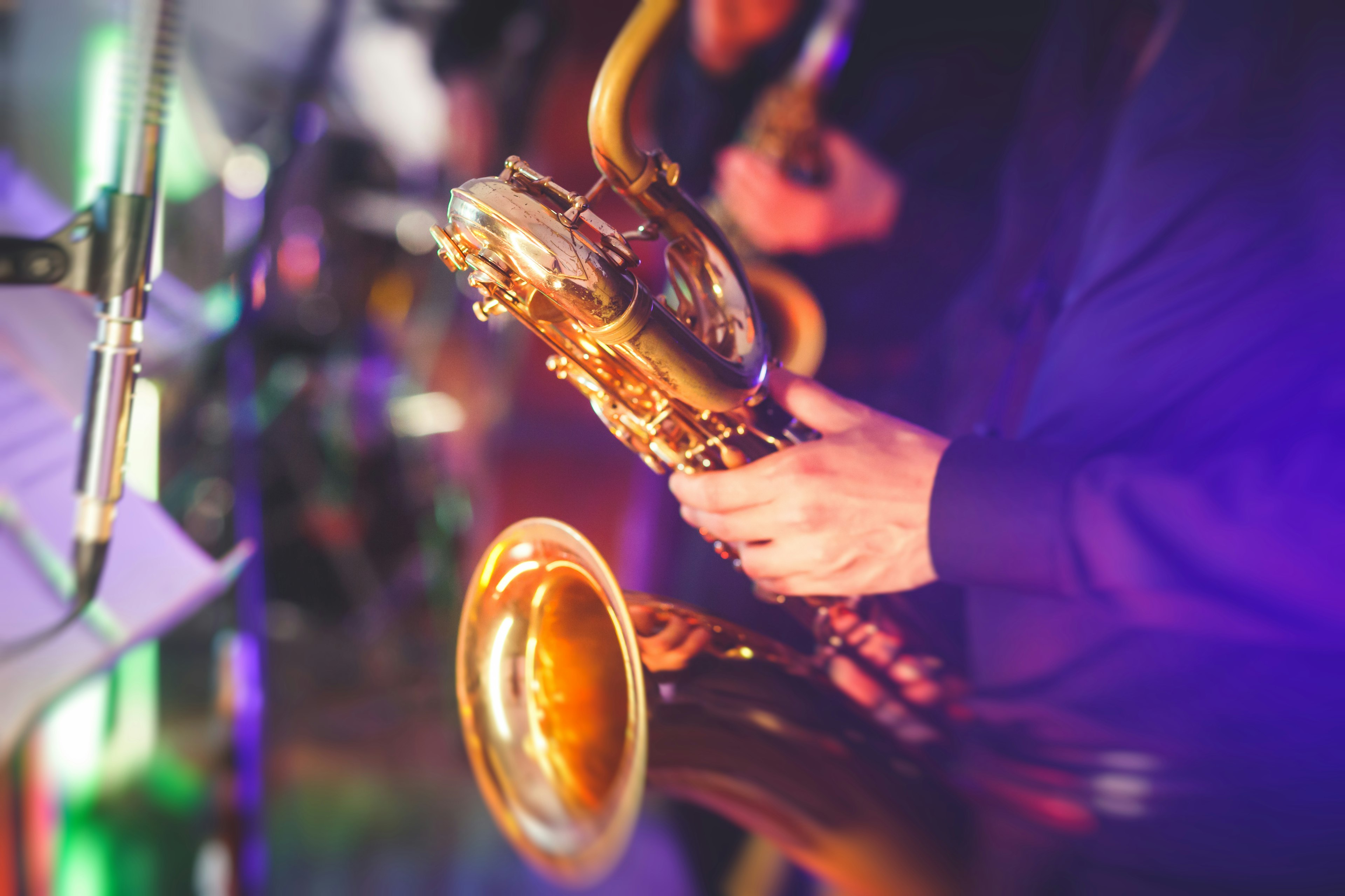 Close-up of a saxophone player performing with a musical jazz band.