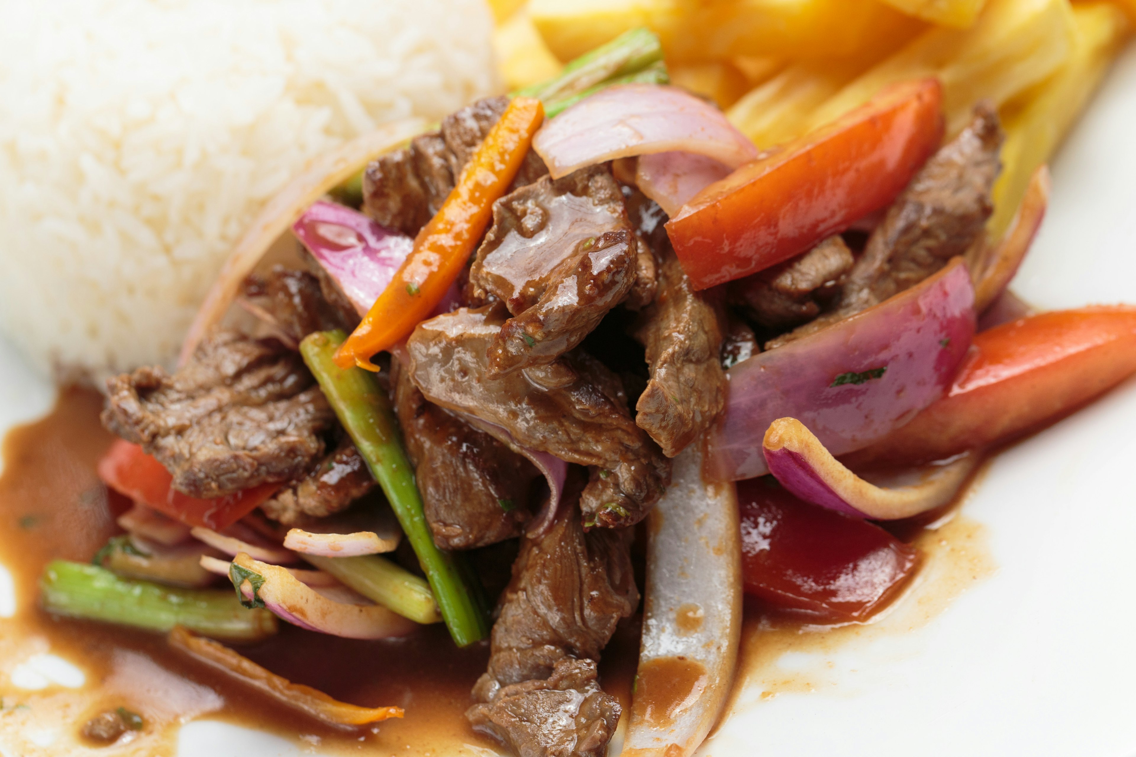 Peruvian food "lomo saltado": Salted beef with tomatoes, onion, fried potatoes and rice.