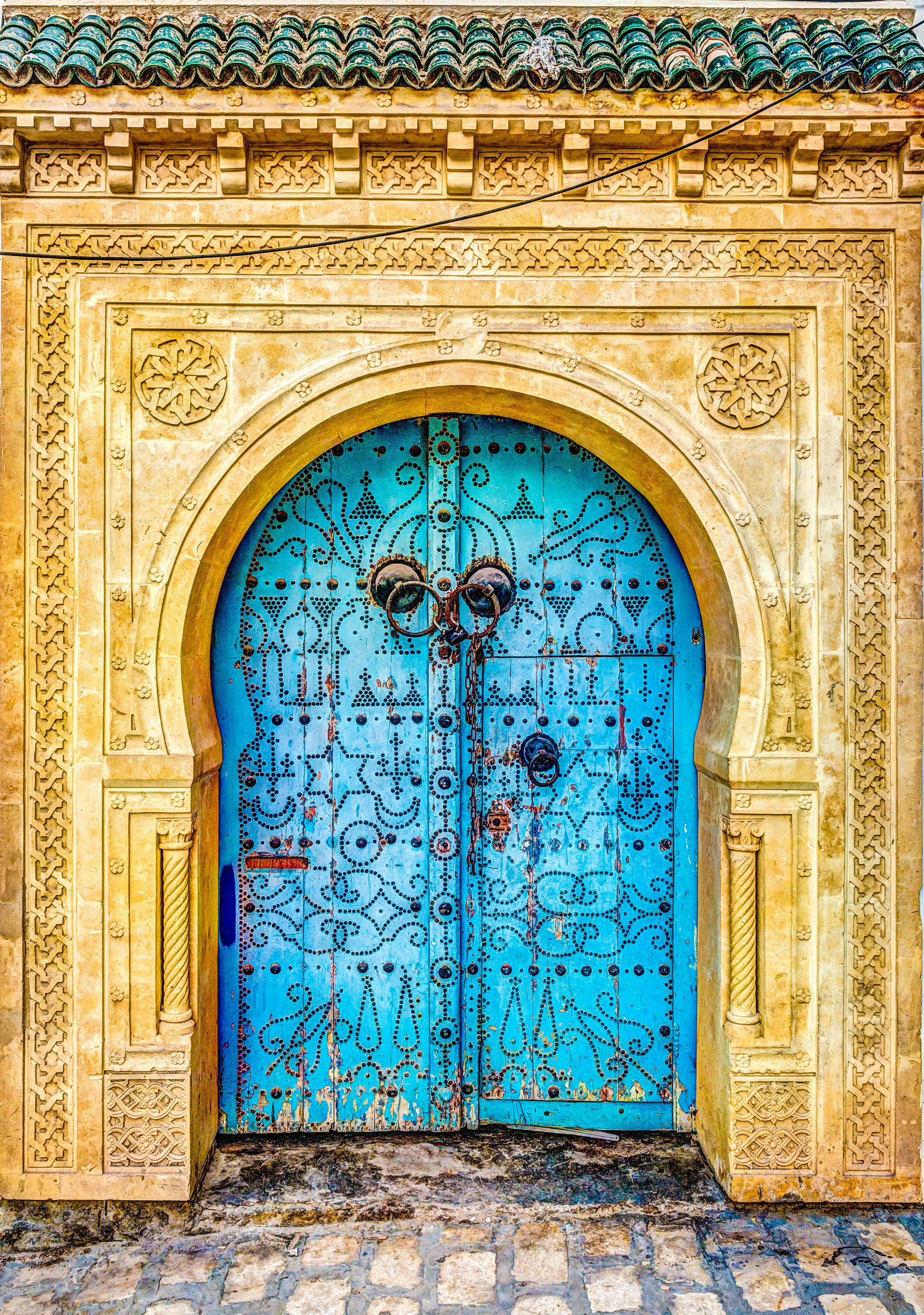 Traditionally-styled blue door at a medina in Tunisia.