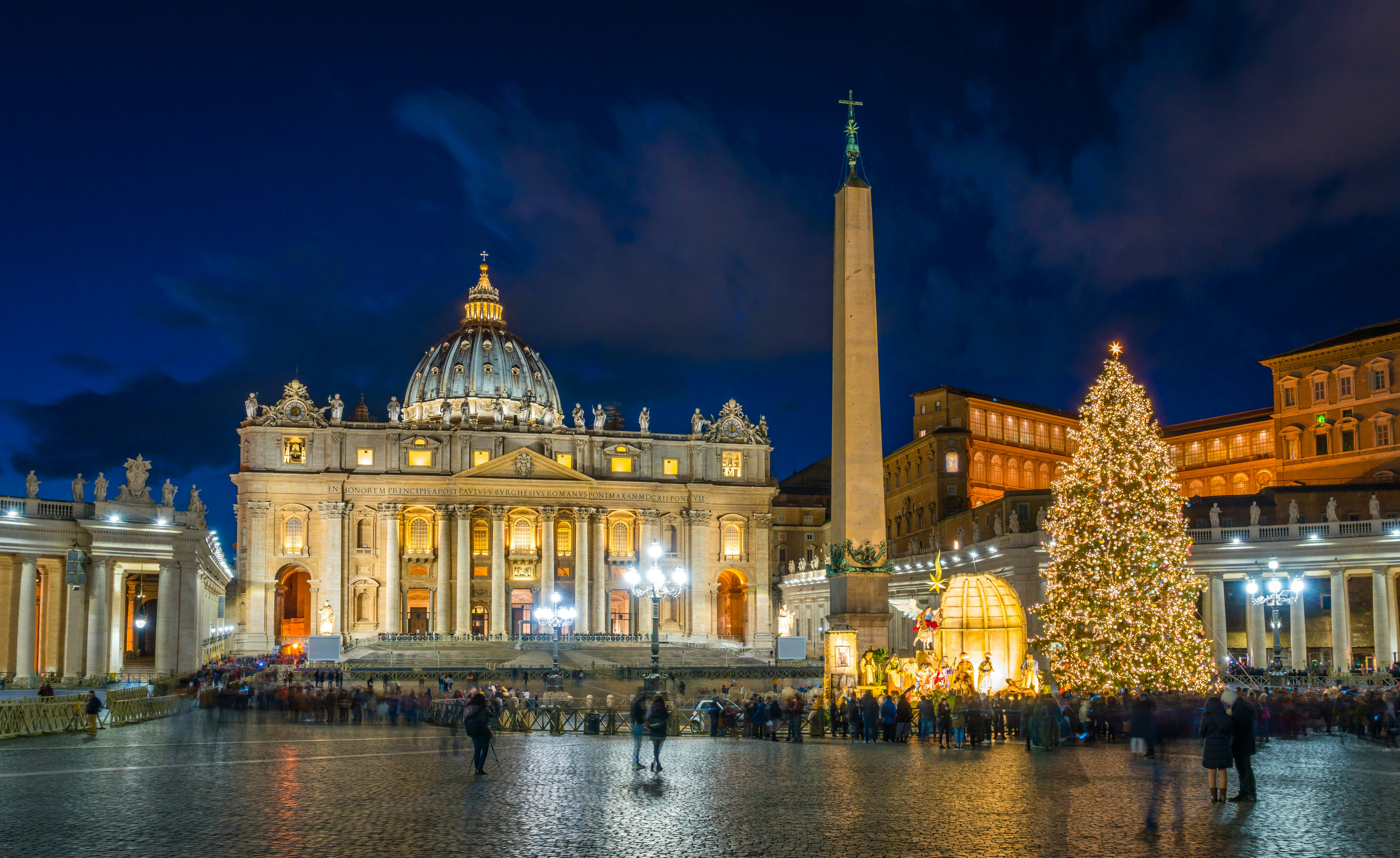 Exterior of Saint Peter's Basilica at night with Christmas decorations in Rome.