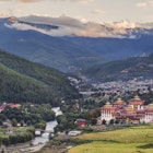 A view over Thimphu, with the Tashi Chho Dzong towering beside the river.
