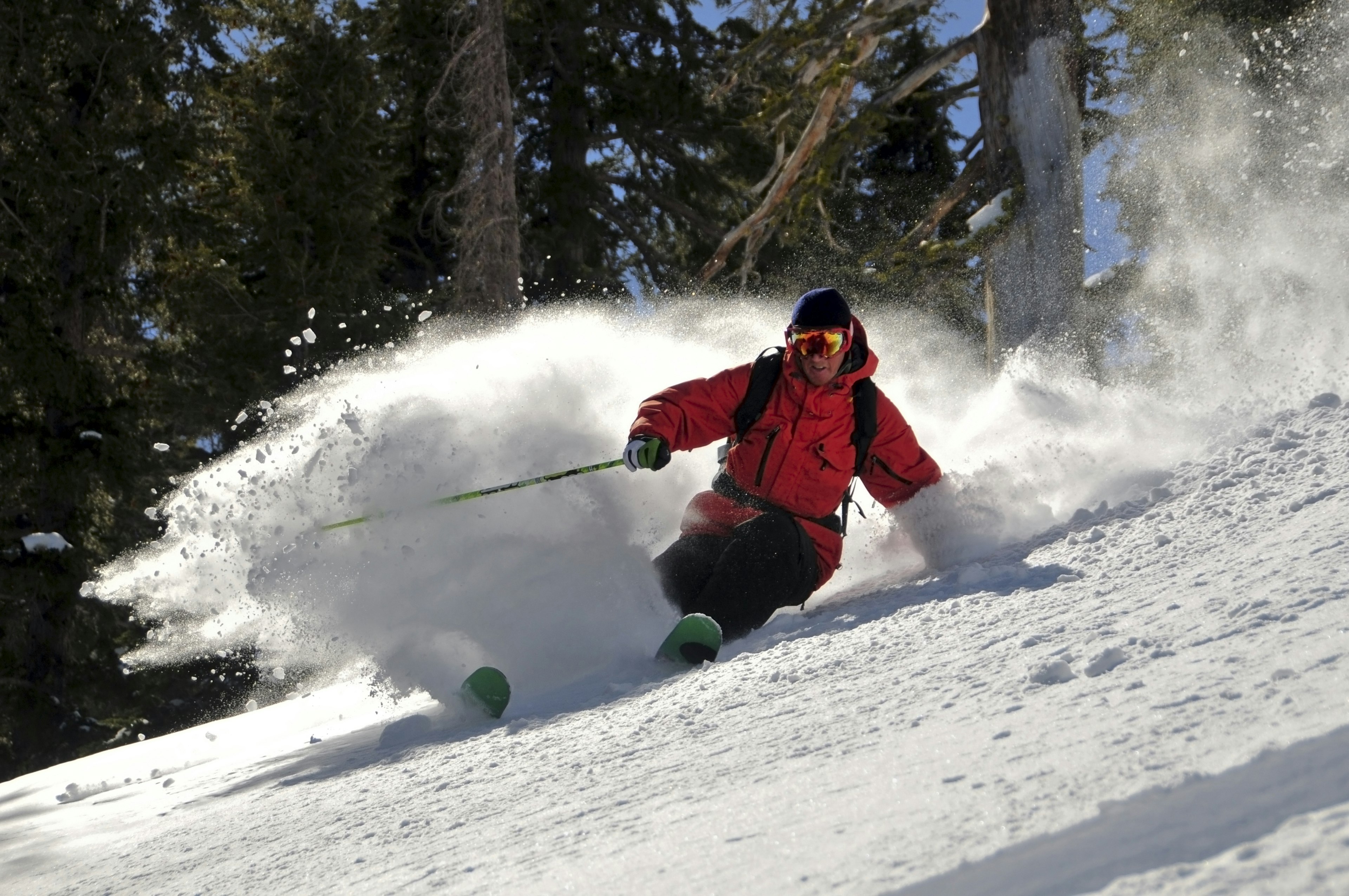 A person skiing downhill in a red jacket.