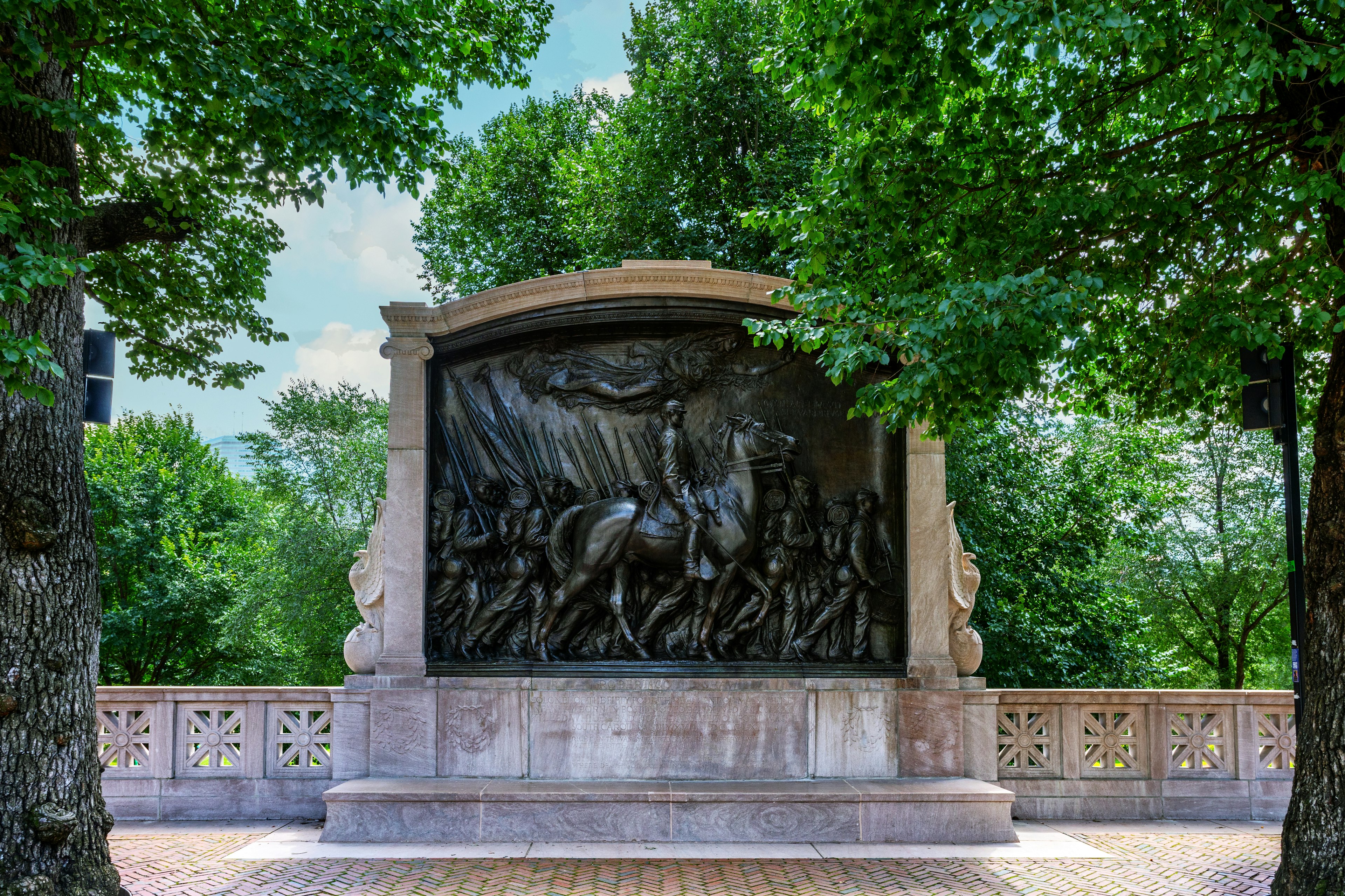 A bronze relief sculpture of a man on a horse and an armed regiment going into battle