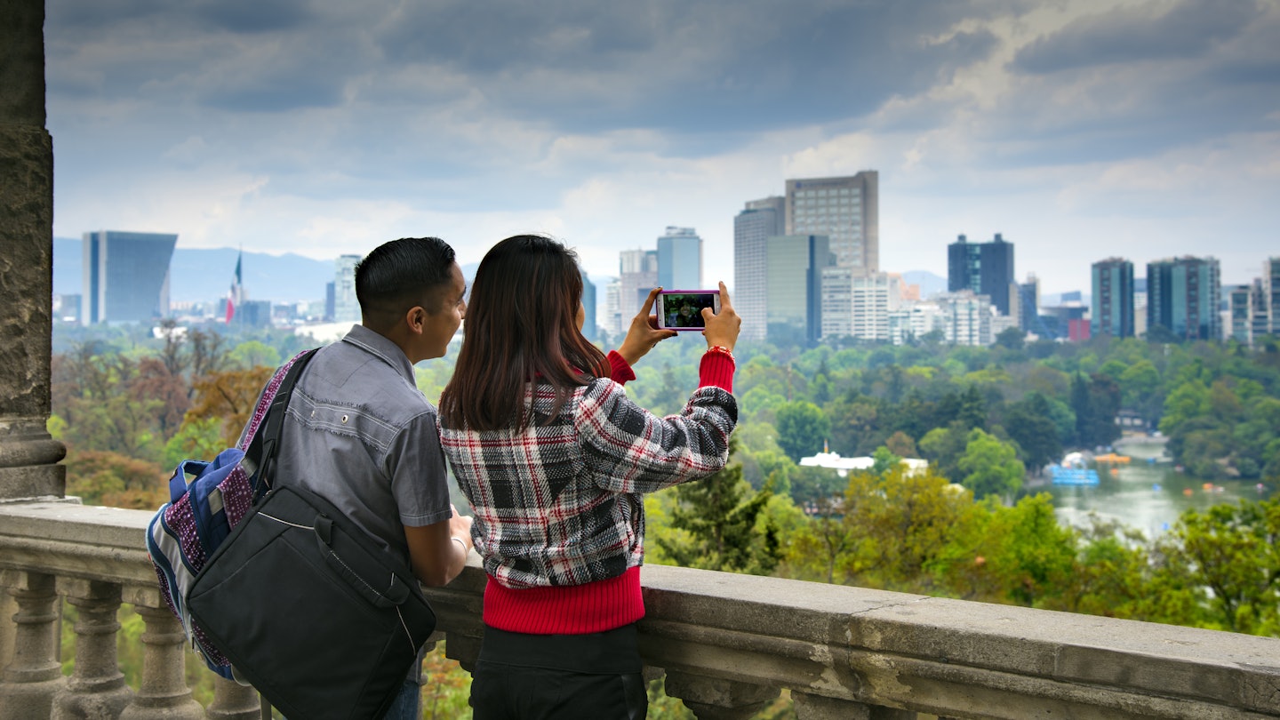 Visitors to Chapultepec Park take photographs of the views of Mexico City. The park is on top of a rock formation called Chapultepec Hill, and is the largest city park in Latin America.