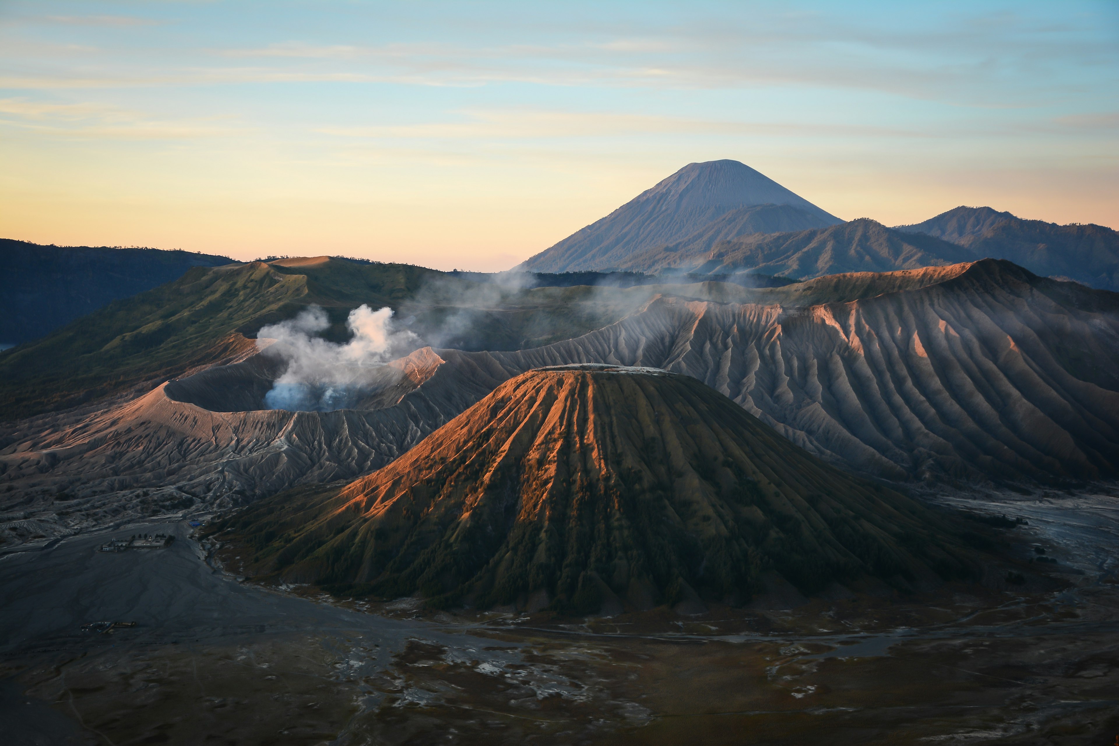 A series of smoking volcanic craters at sunrise