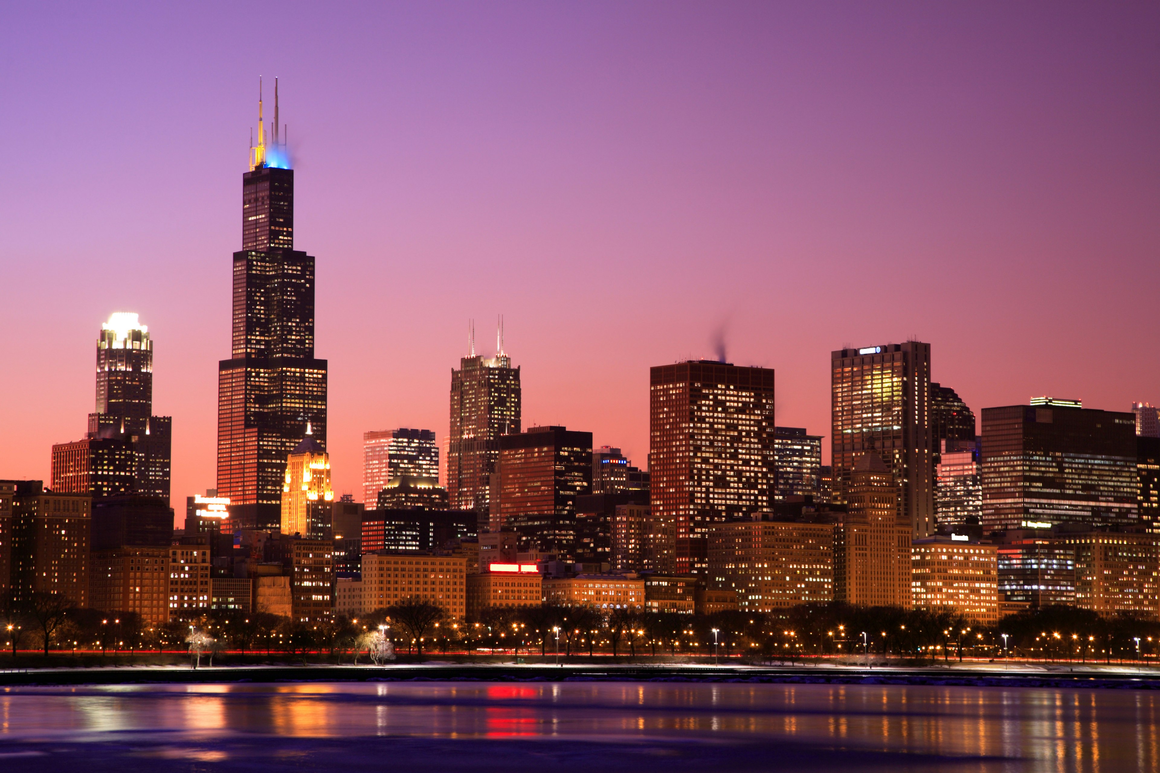 Chicago skyline at dusk, with the Willis Tower rising against a colorful sky.