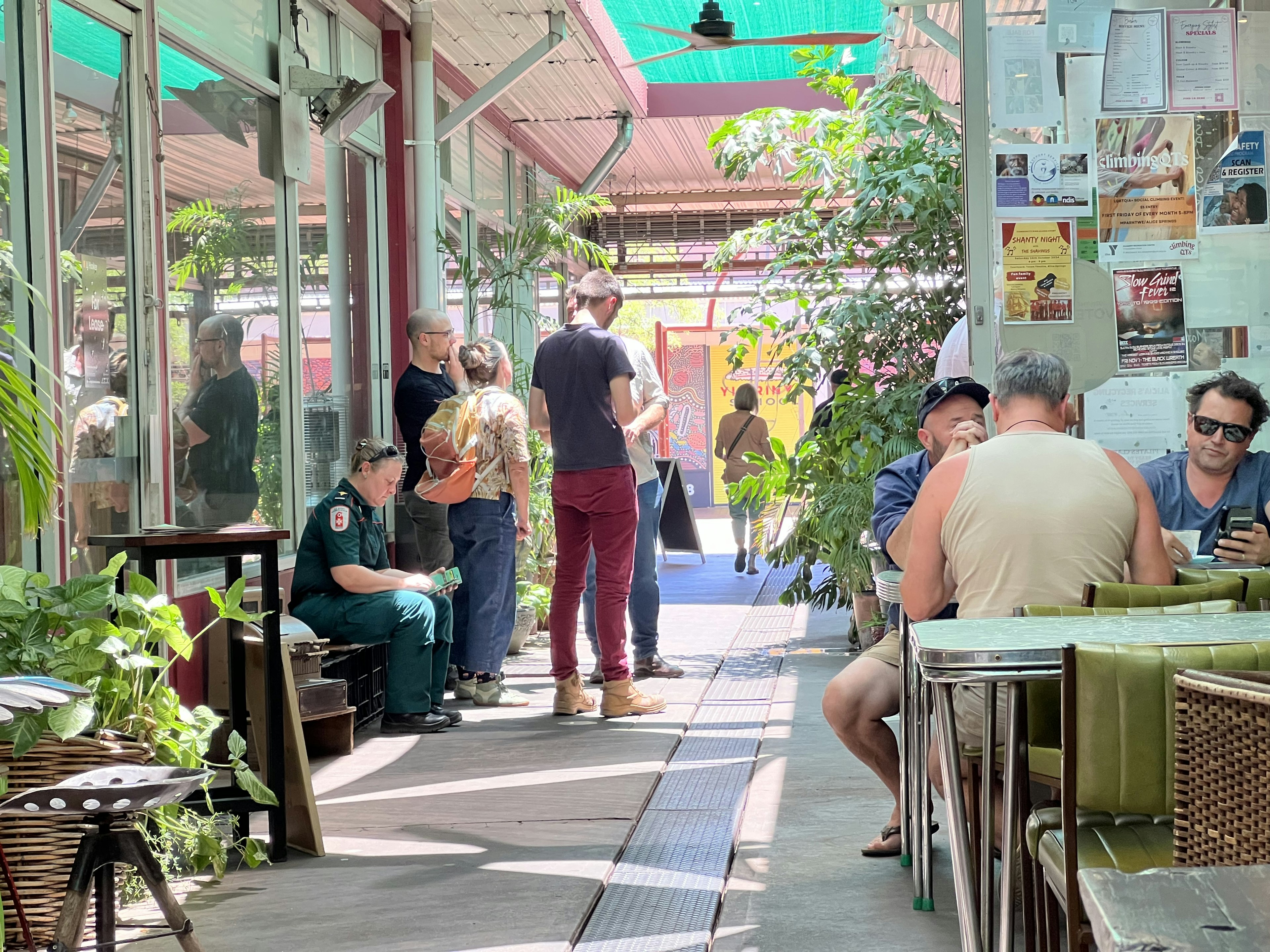 People sit outside a cafe in an alleyway