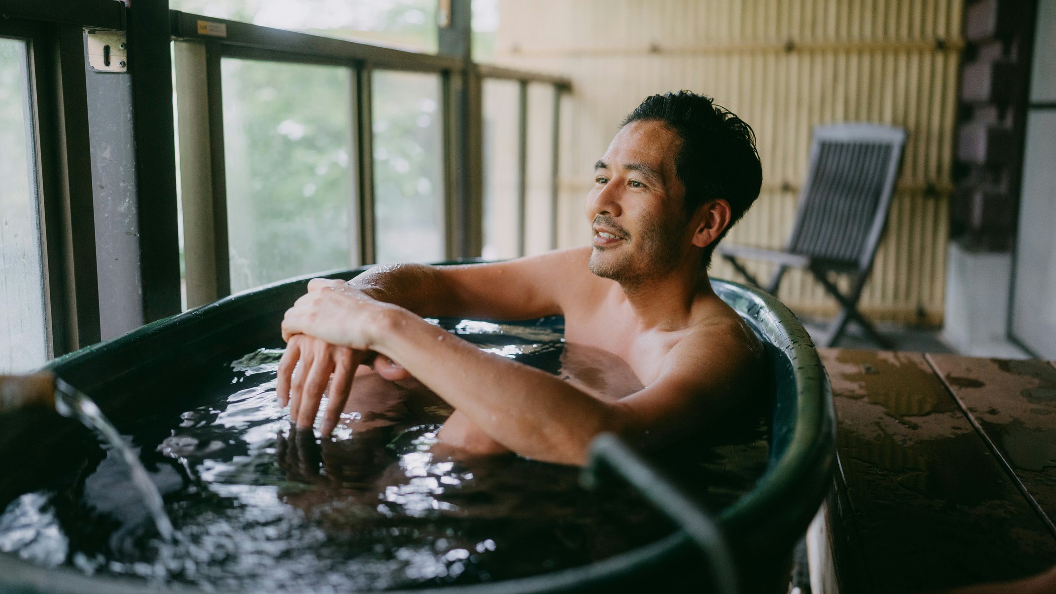 A man bathing in an onsen bath in Japan.